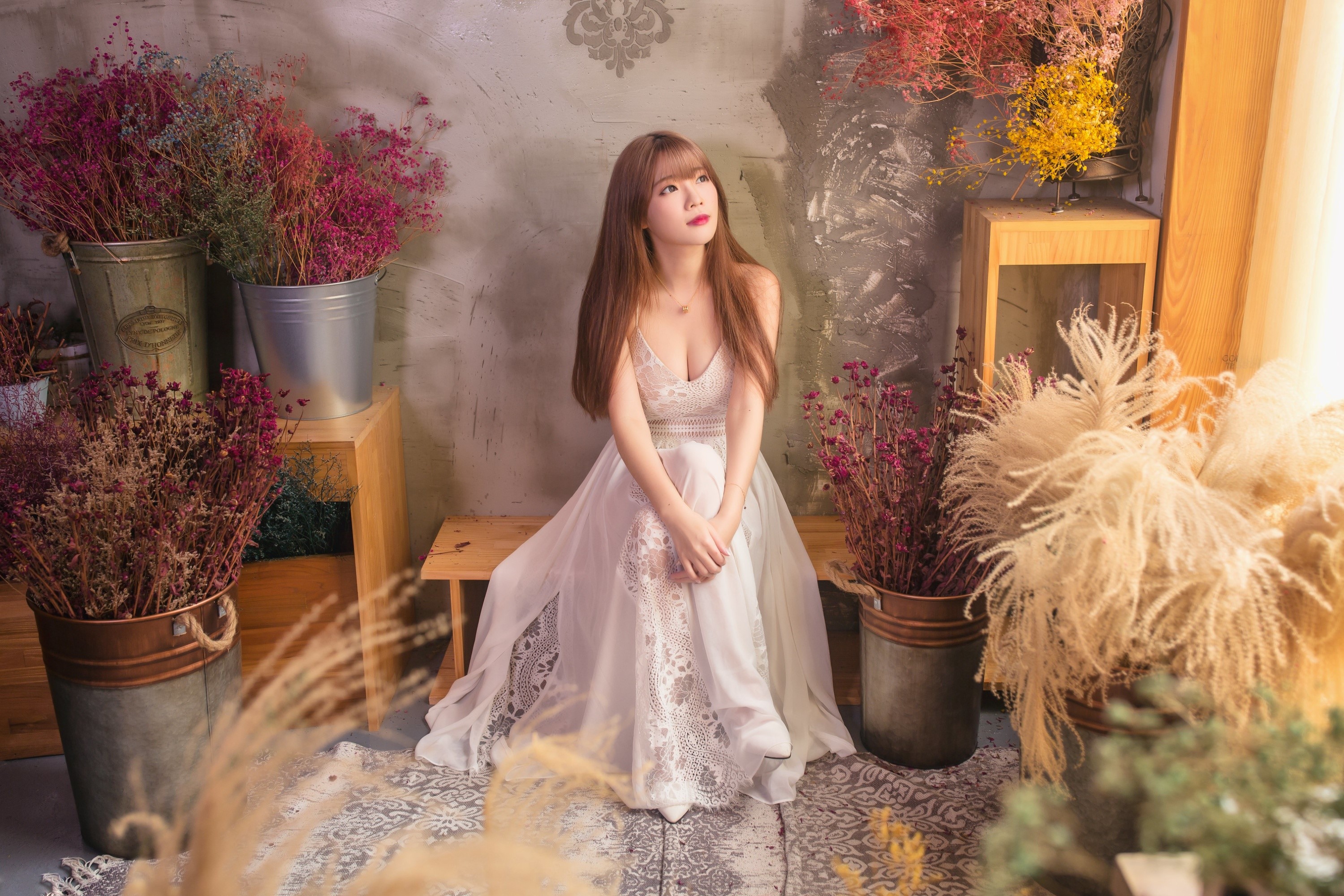 Asian woman in white dress sitting among flowers HD Wallpaper