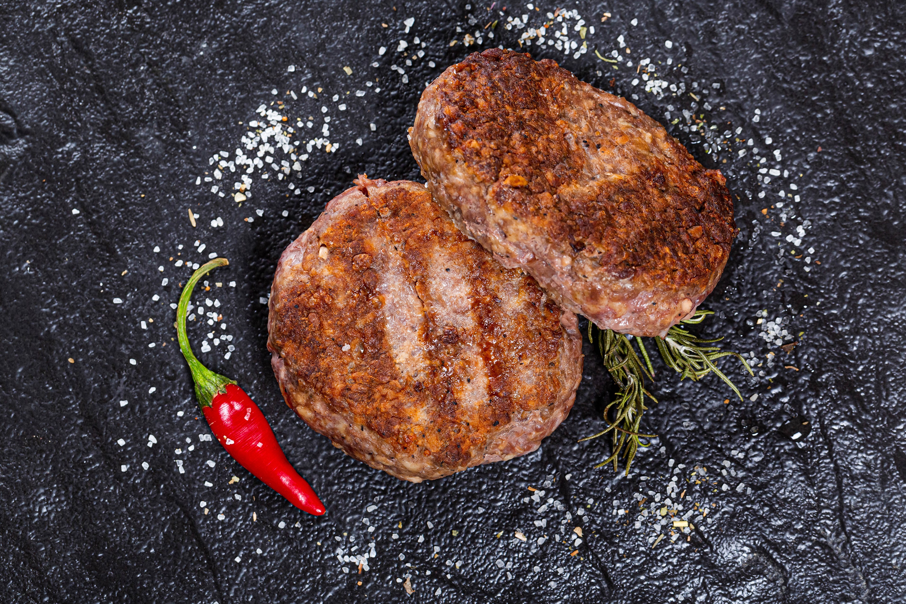 Two grilled Frikadeller with chili pepper and salt HD Wallpaper