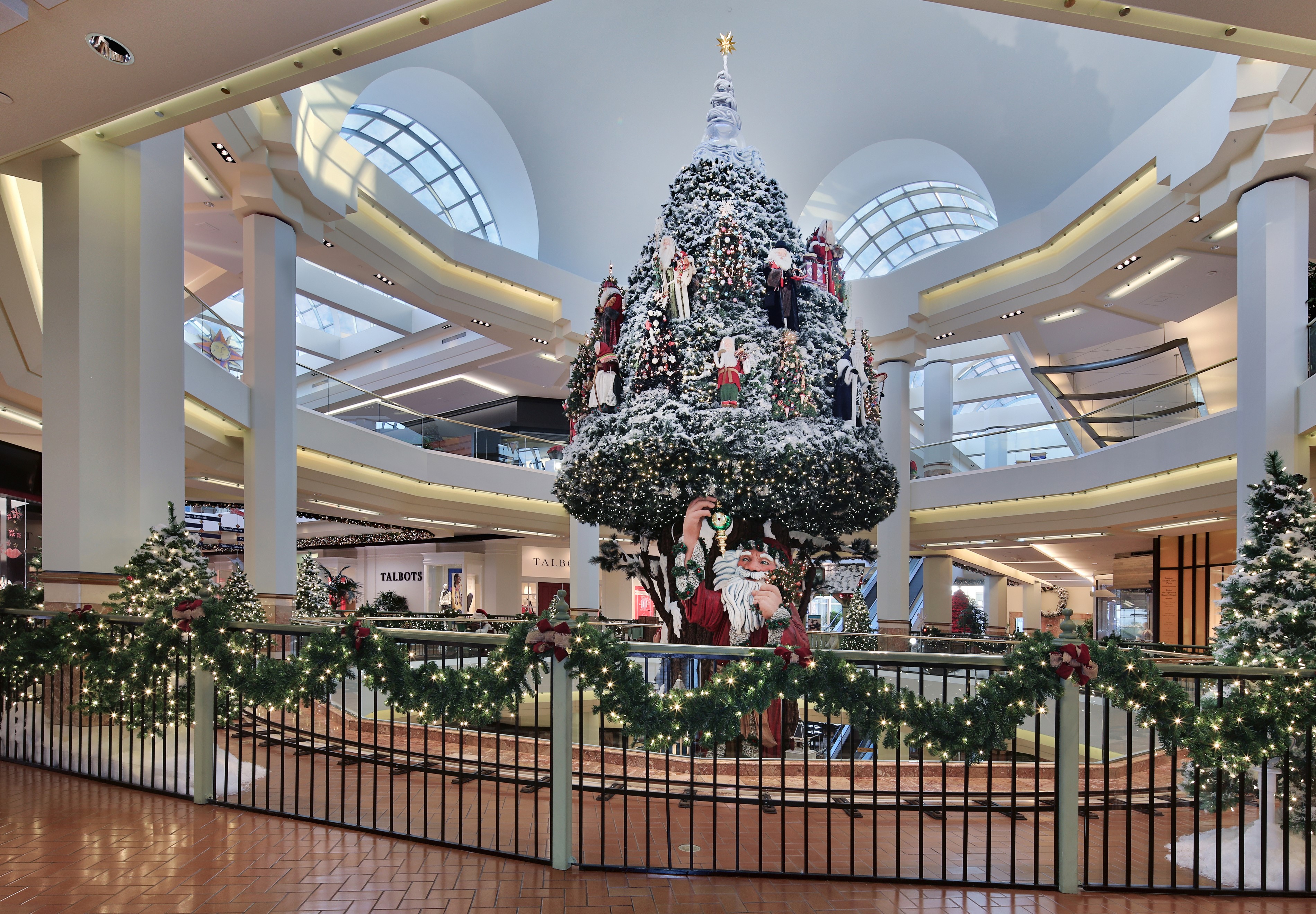 Christmas tree with Santa Claus and fairy lights in a mall HD Wallpaper
