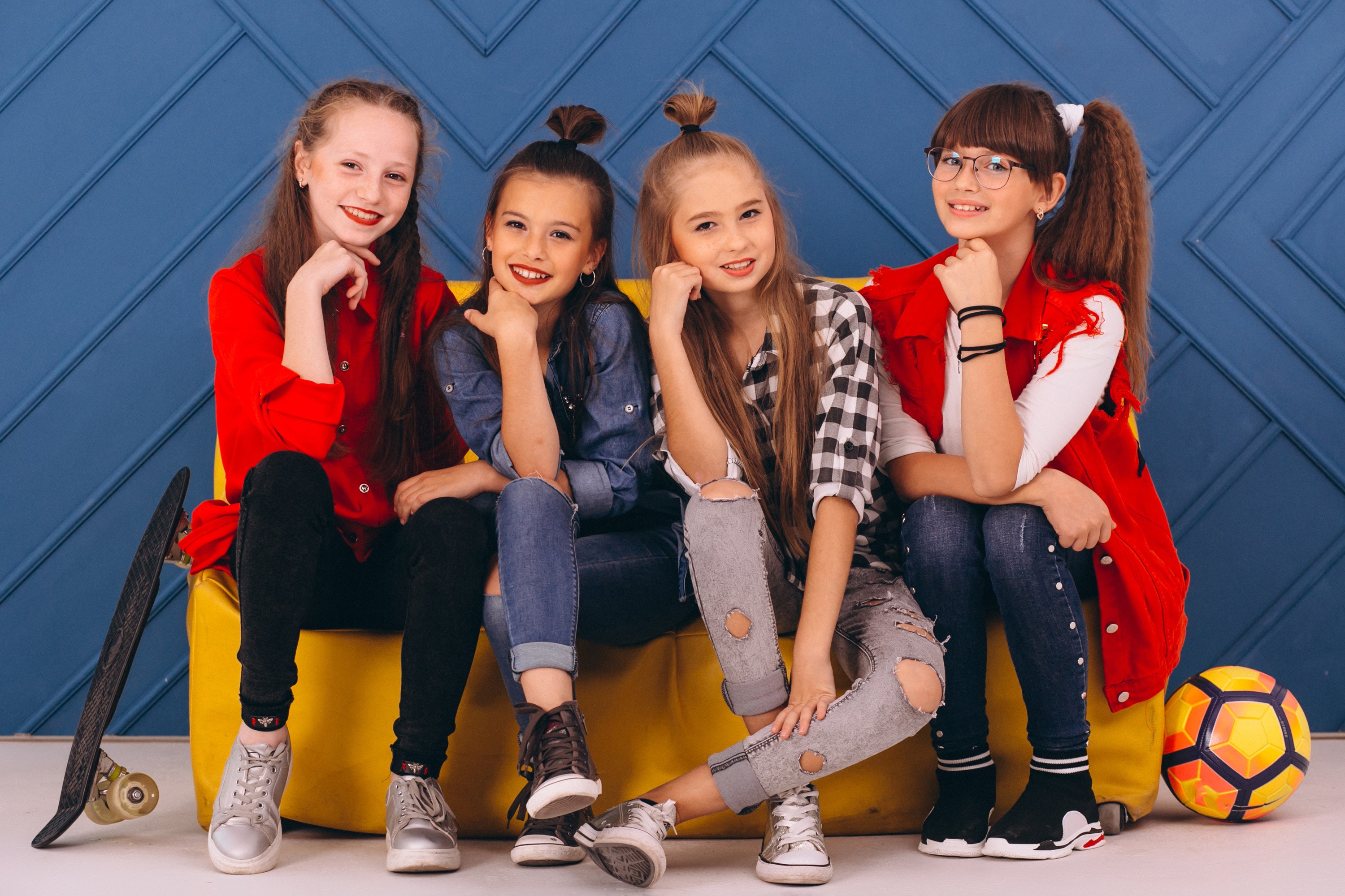 Four young girls sitting on a yellow couch HD Wallpaper