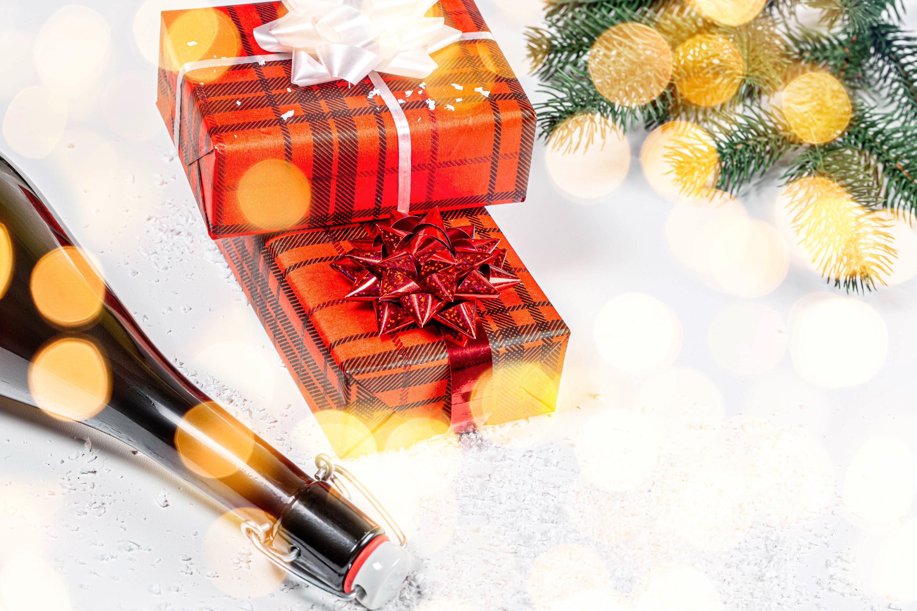 Christmas gifts and champagne bottle with festive lights HD Wallpaper