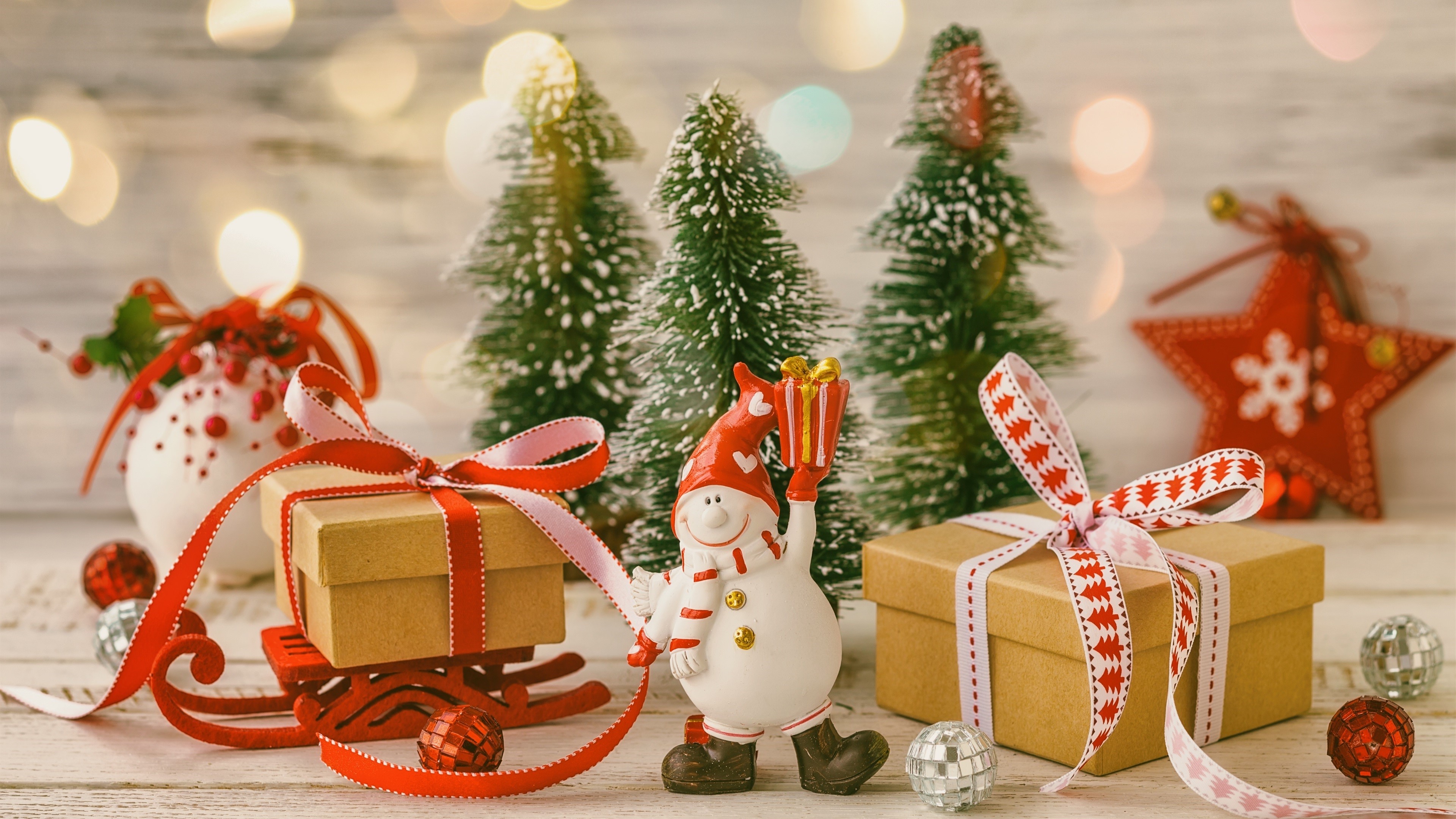 Christmas scene with gifts, trees, and a snowman HD Wallpaper