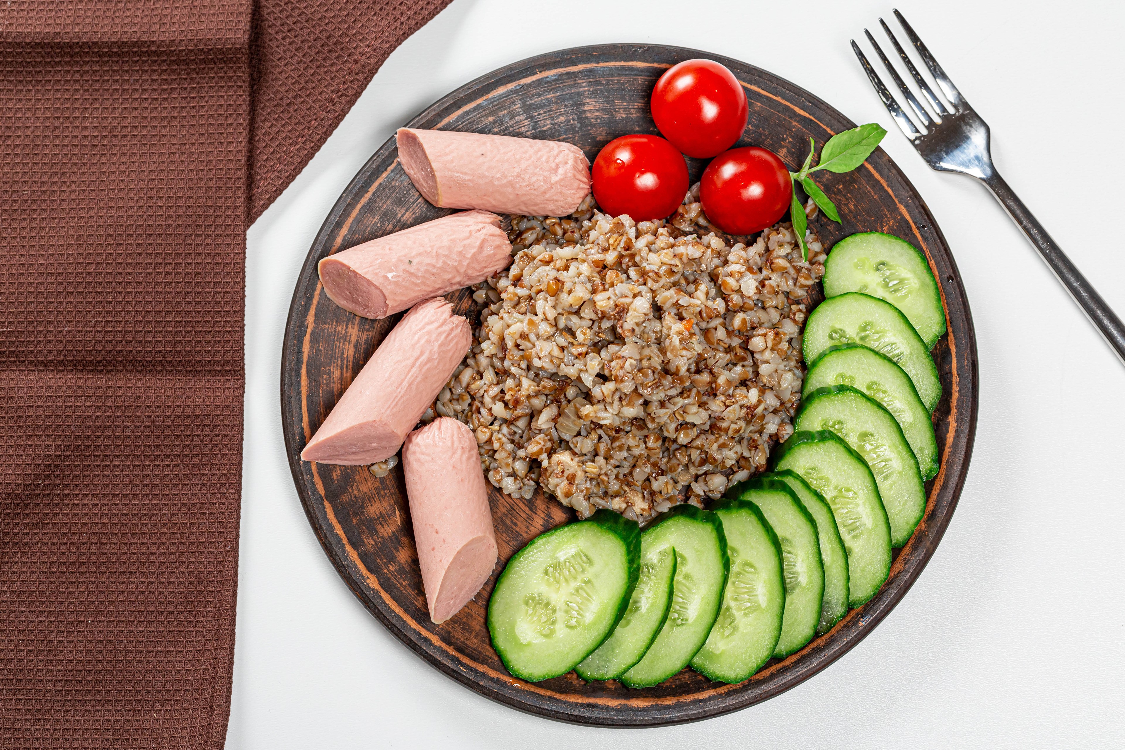 Buckwheat porridge with sausages, tomatoes, and cucumbers on a plate HD Wallpaper