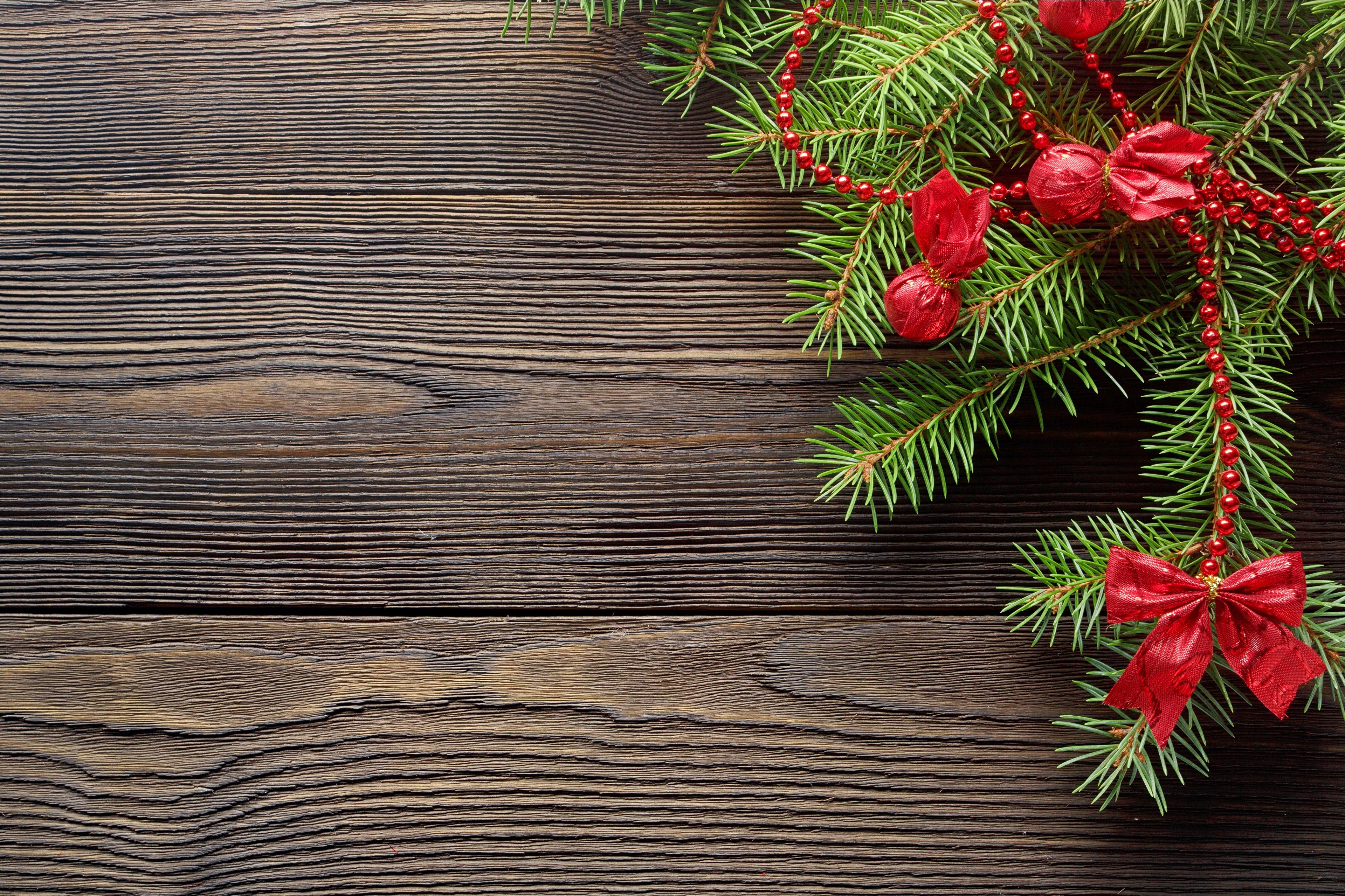 Christmas fir branches with red ornaments on wood HD Wallpaper