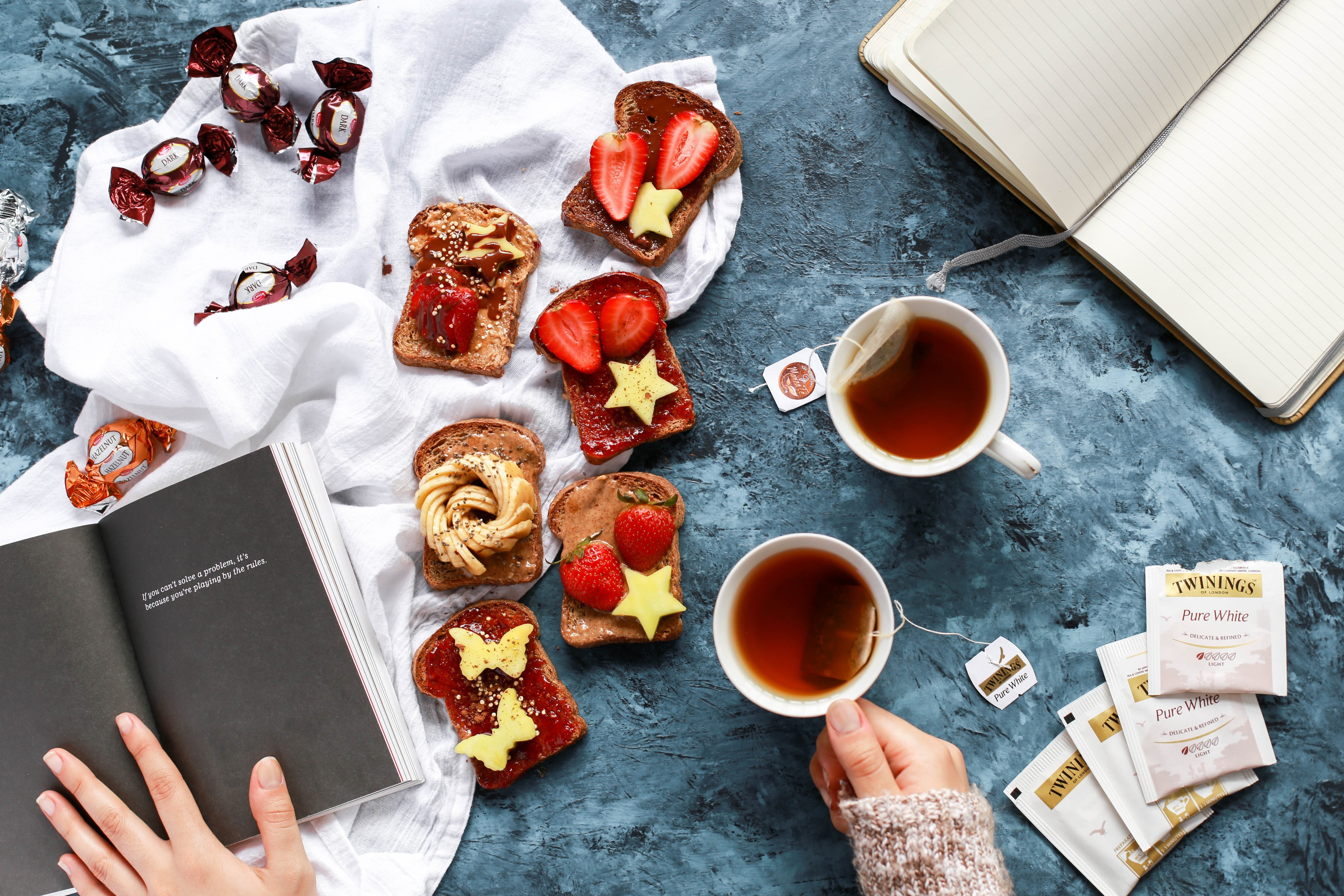 Tea and decorated toast with candies and books HD Wallpaper