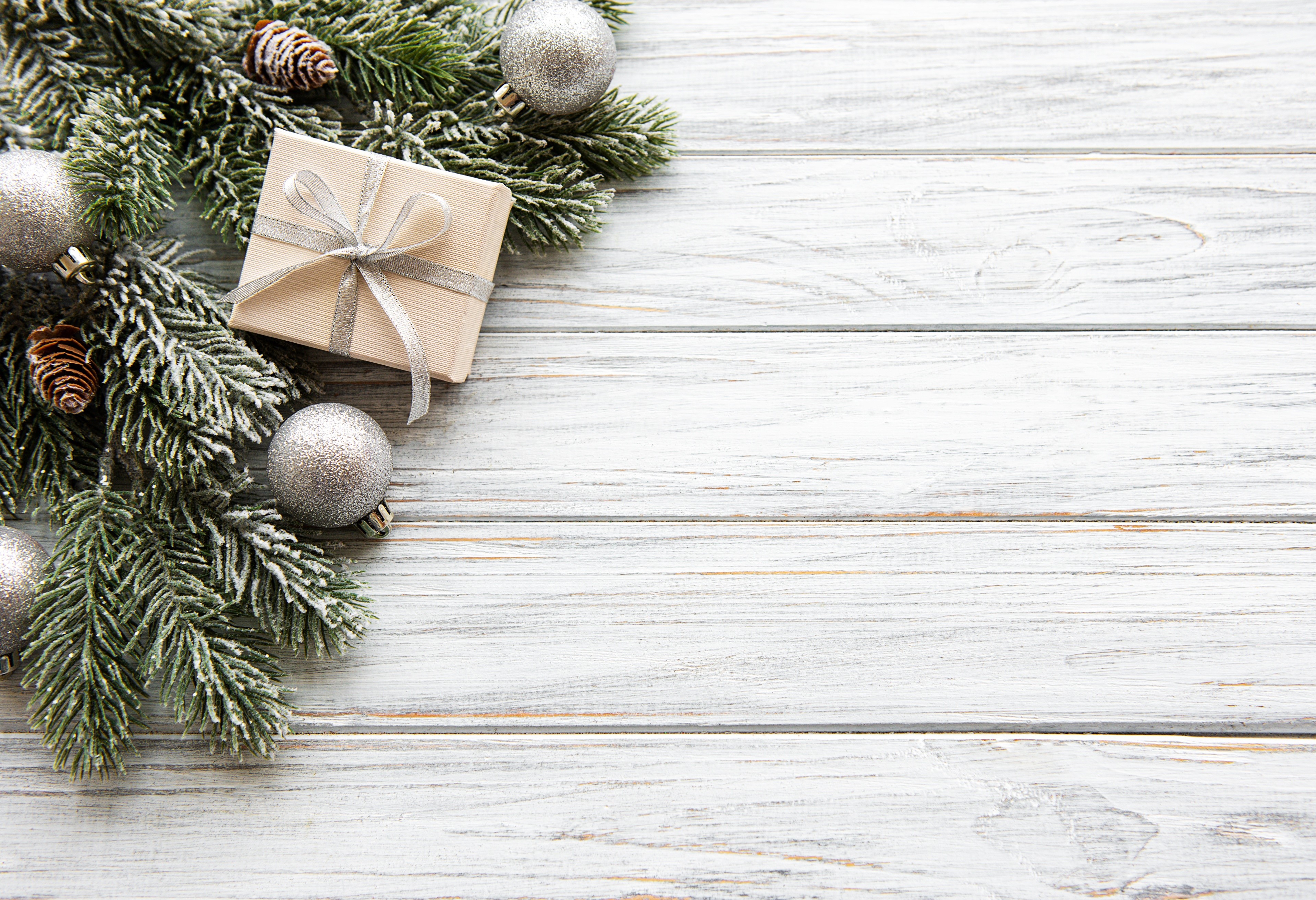 Christmas gift box with pine cones and ornaments on wood HD Wallpaper