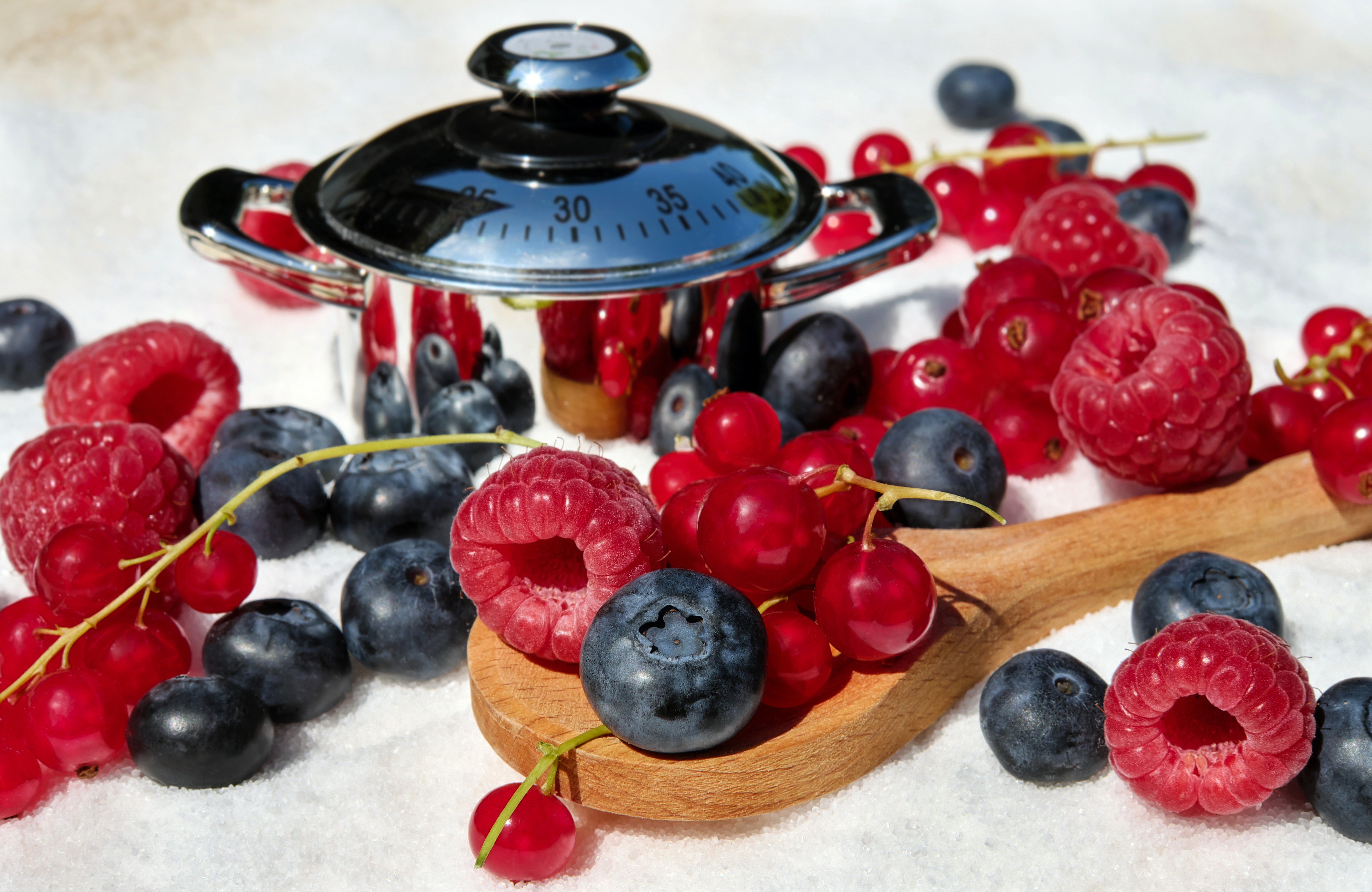 Berries and a pot on a white surface HD Wallpaper