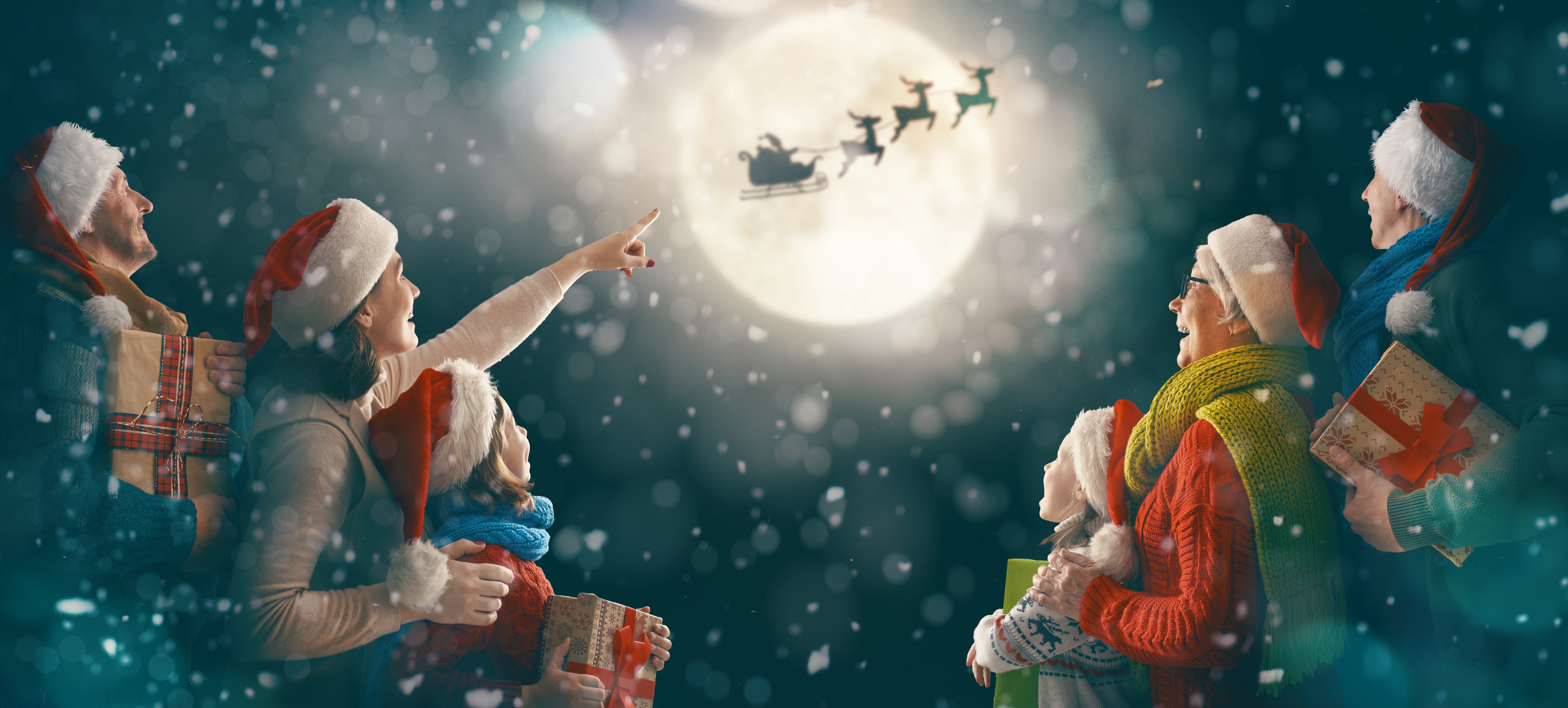 Family watching Santa Claus fly in the sky HD Wallpaper