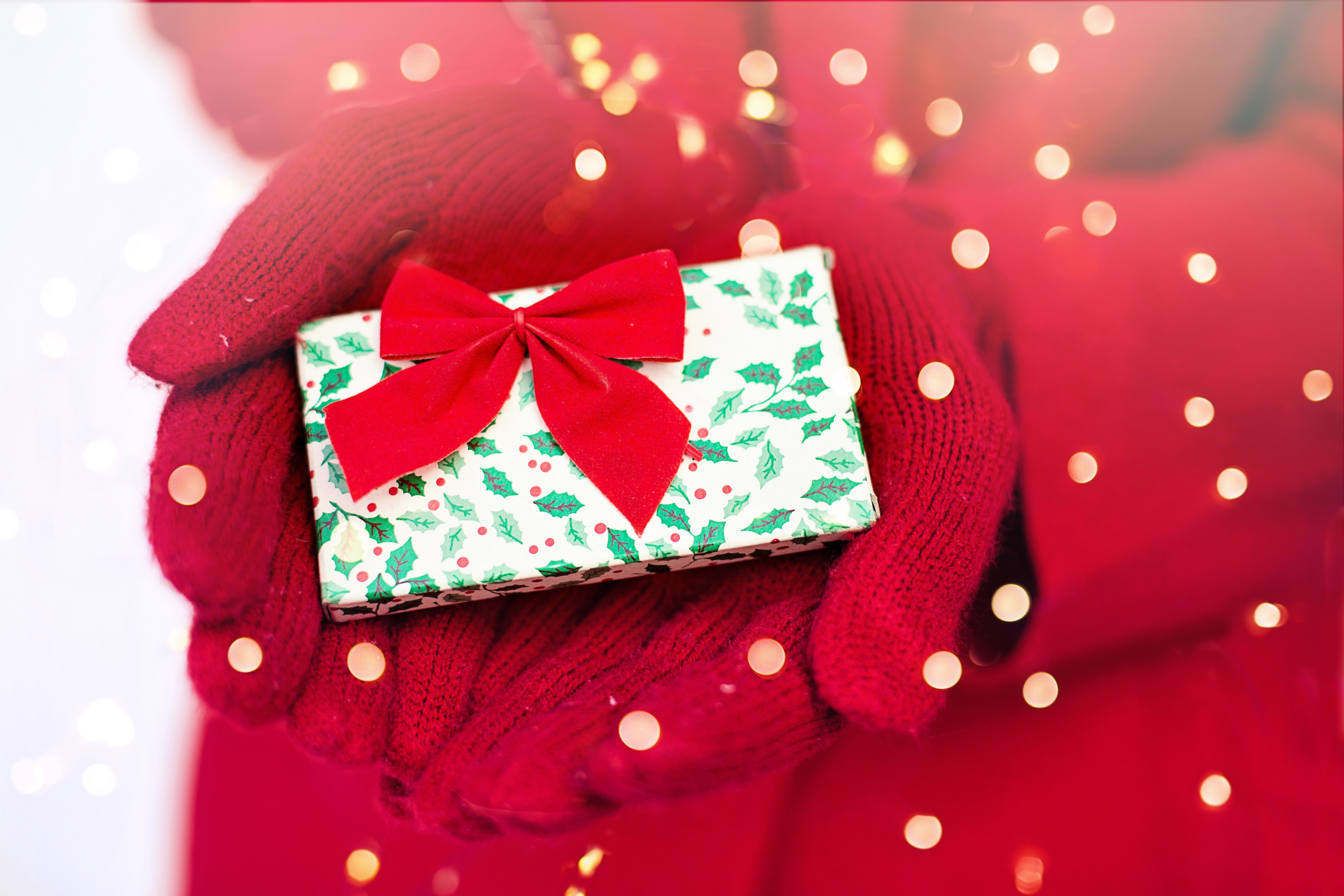 Hands in red mittens holding a Christmas gift HD Wallpaper