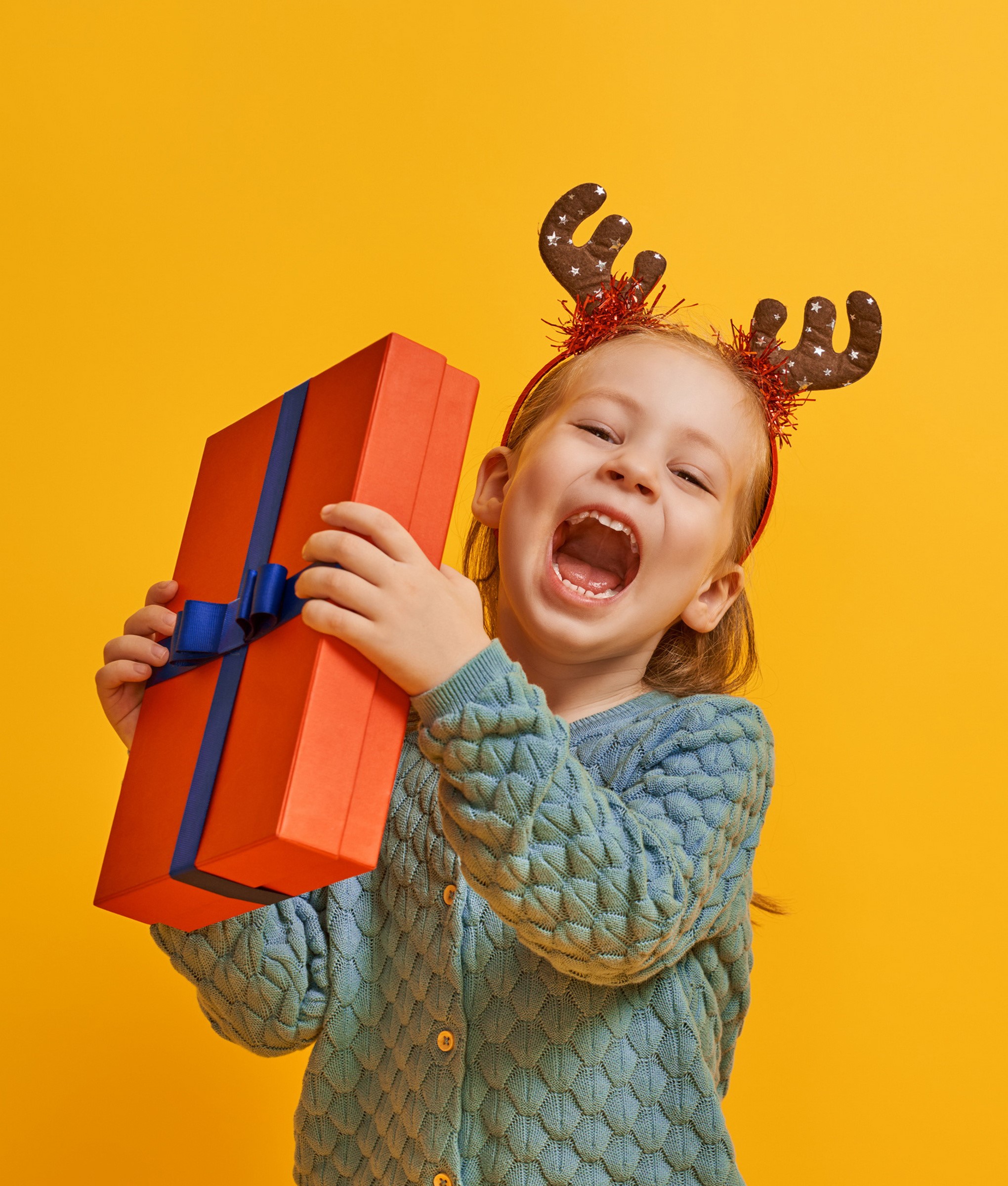 Girl with reindeer antlers holding a gift HD Wallpaper
