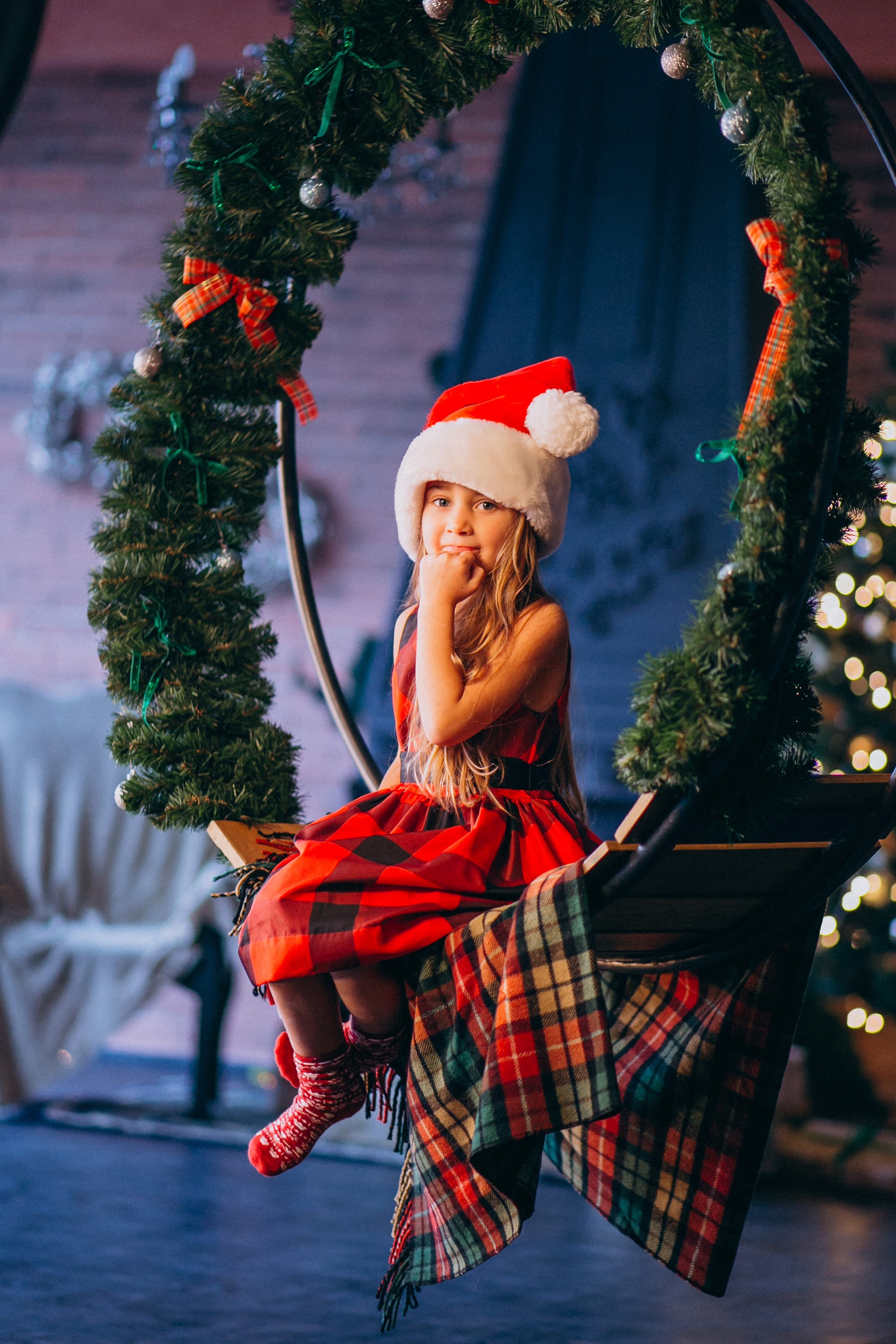 Girl in Santa hat sitting on a Christmas swing HD Phone Wallpaper