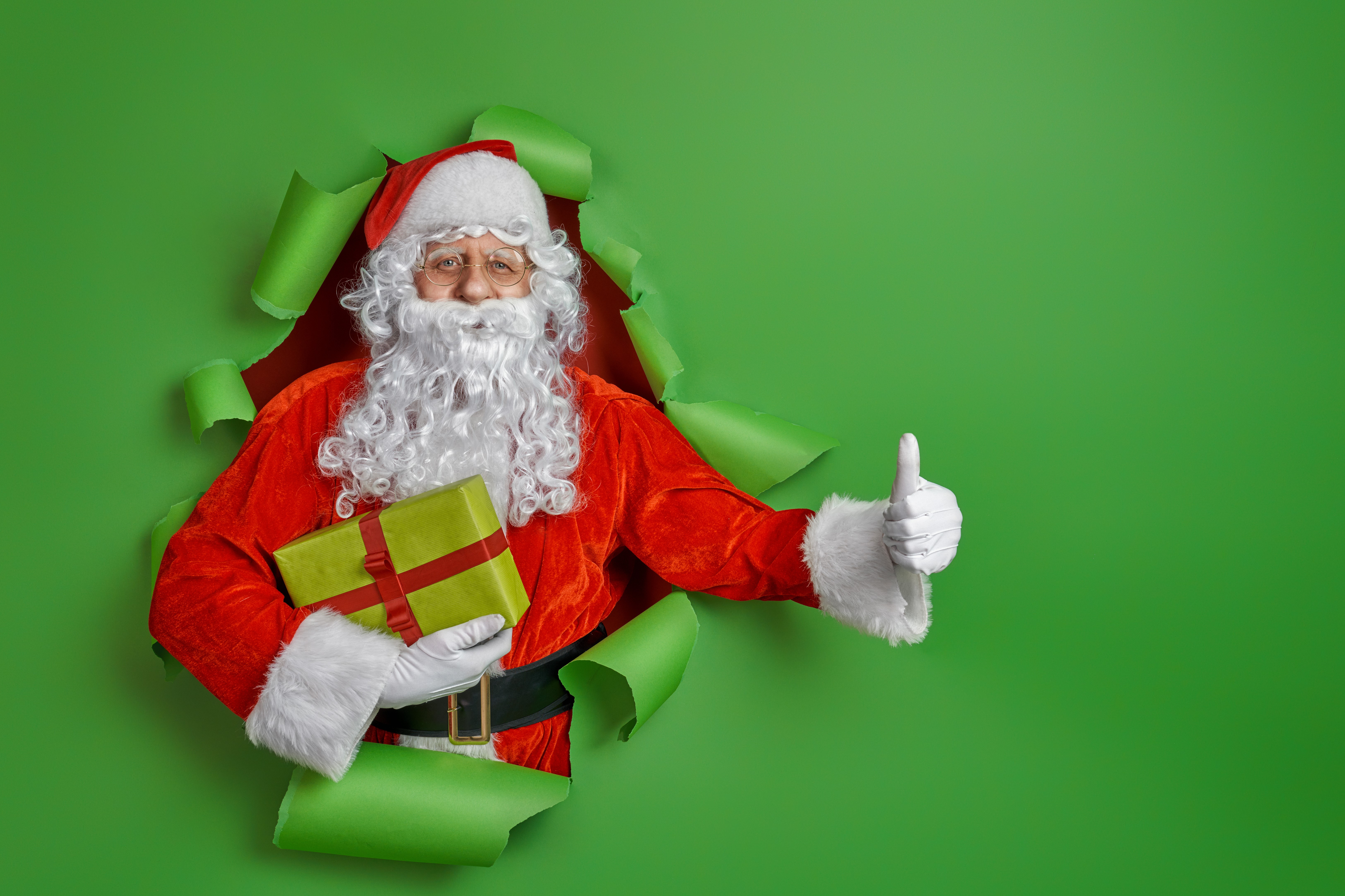 Santa Claus with gift and thumbs up HD Wallpaper