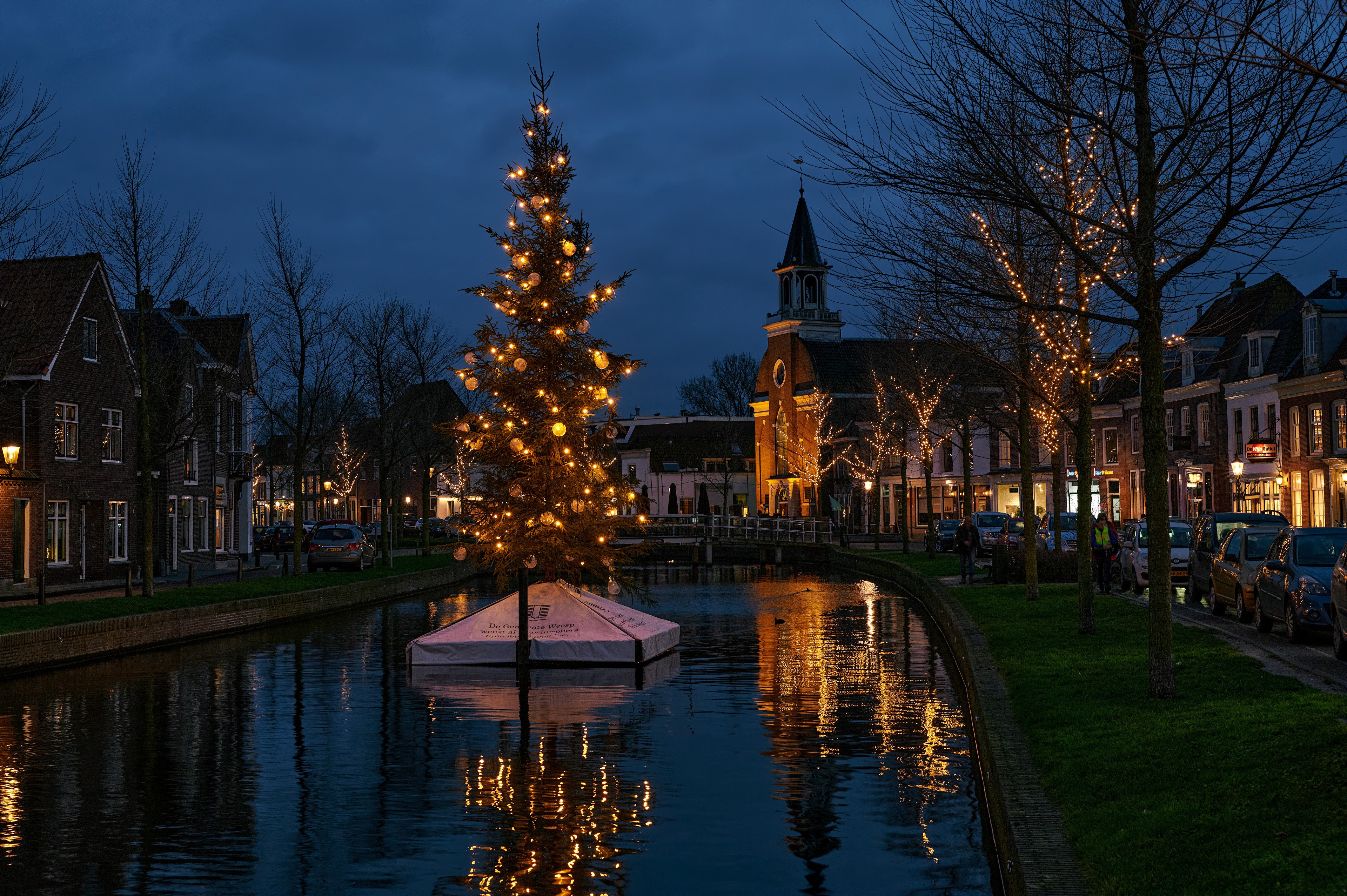Christmas tree on canal in Weesp, Netherlands at dusk HD Wallpaper