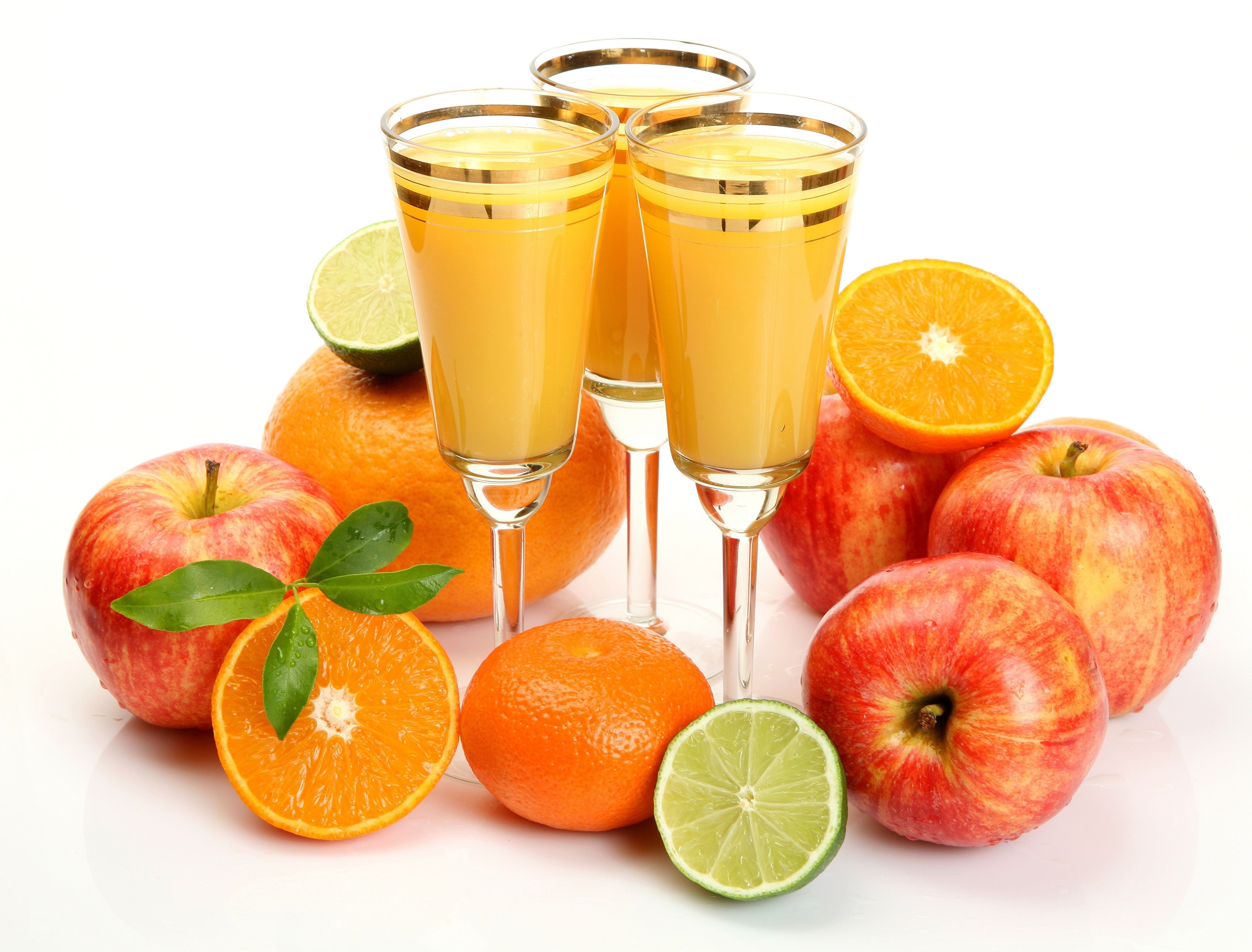 Juice in glasses with apples, oranges, and limes HD Wallpaper