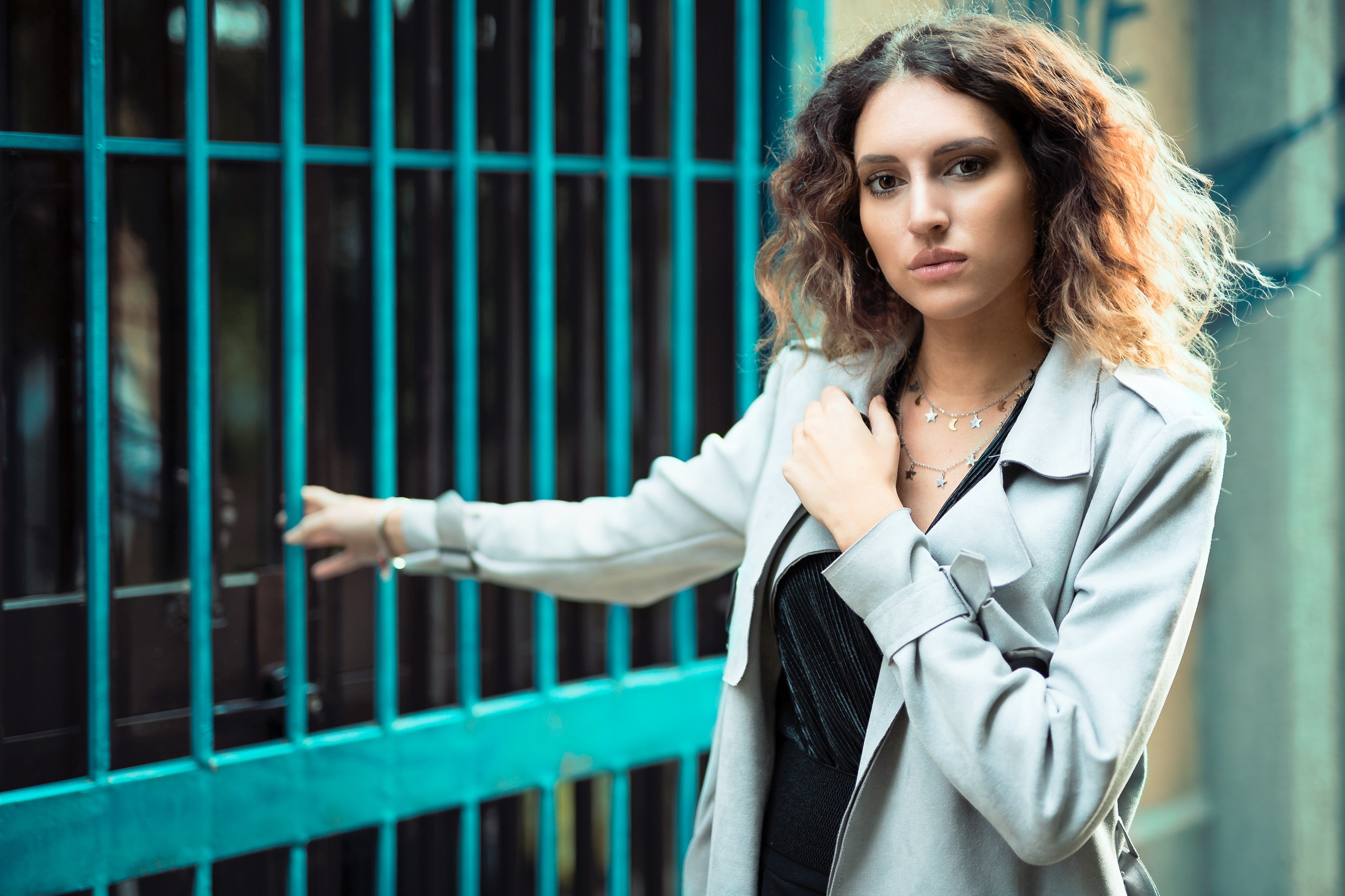 Chiara in a coat by a blue fence HD Wallpaper