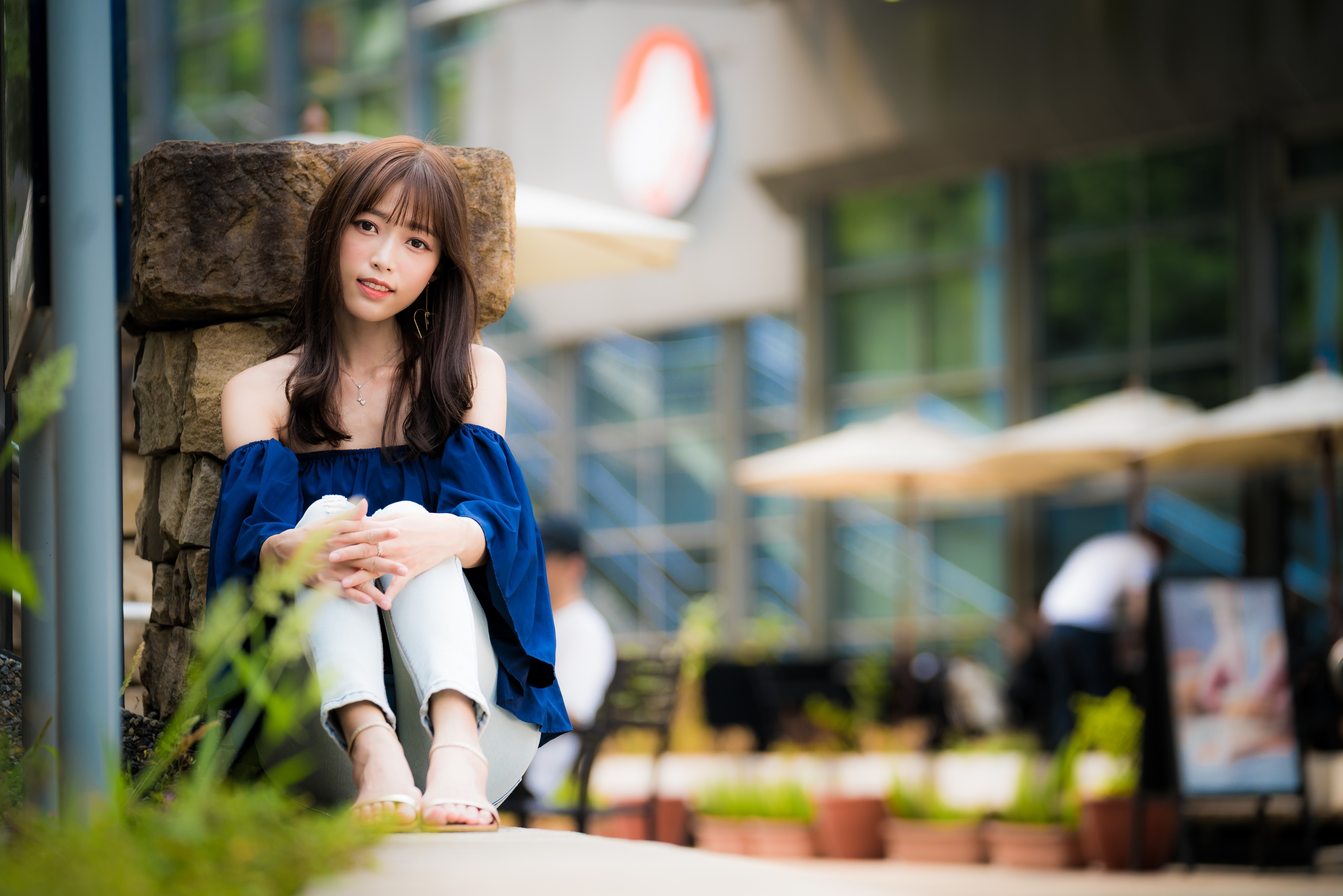 Woman with brown hair sitting outdoors HD Wallpaper