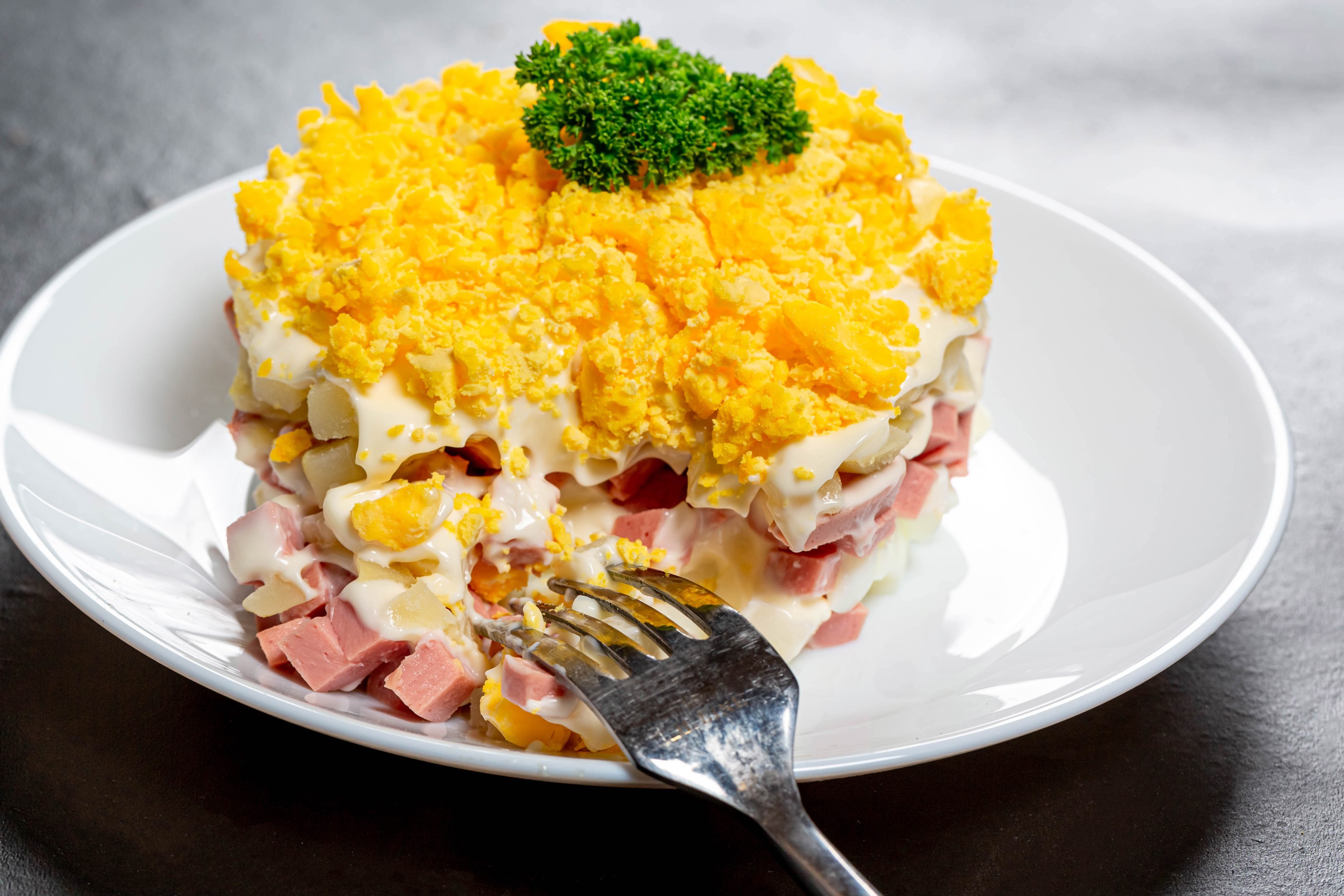 Layered salad with eggs and ham on a plate HD Wallpaper