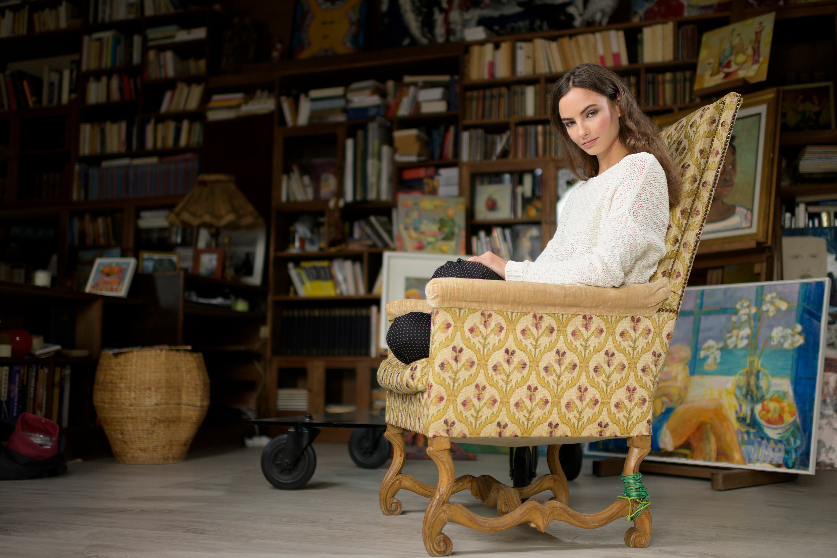 Alena sitting in an armchair in a room full of books HD Wallpaper