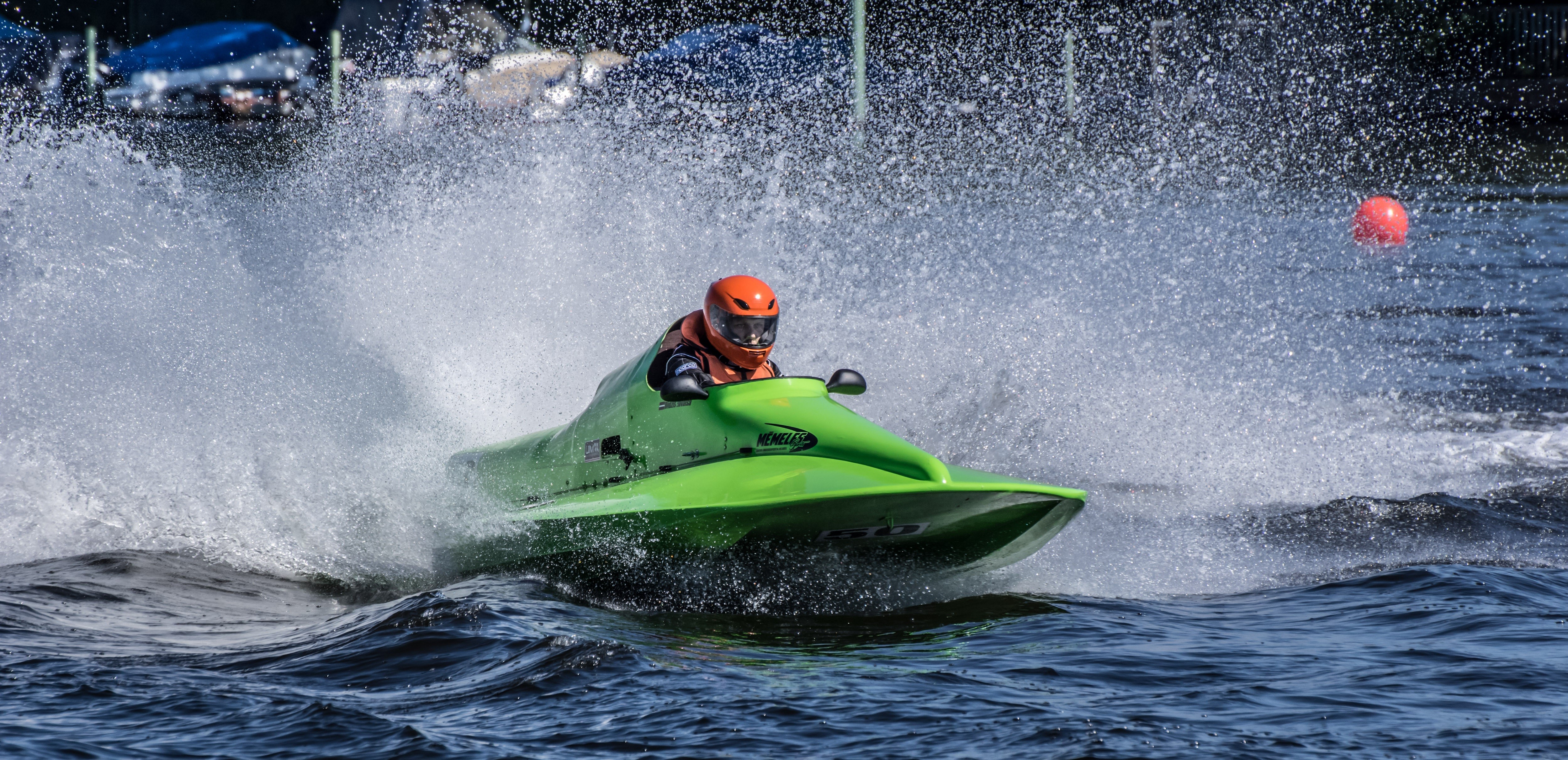 Green hydroplane boat with driver in orange helmet racing HD Wallpaper