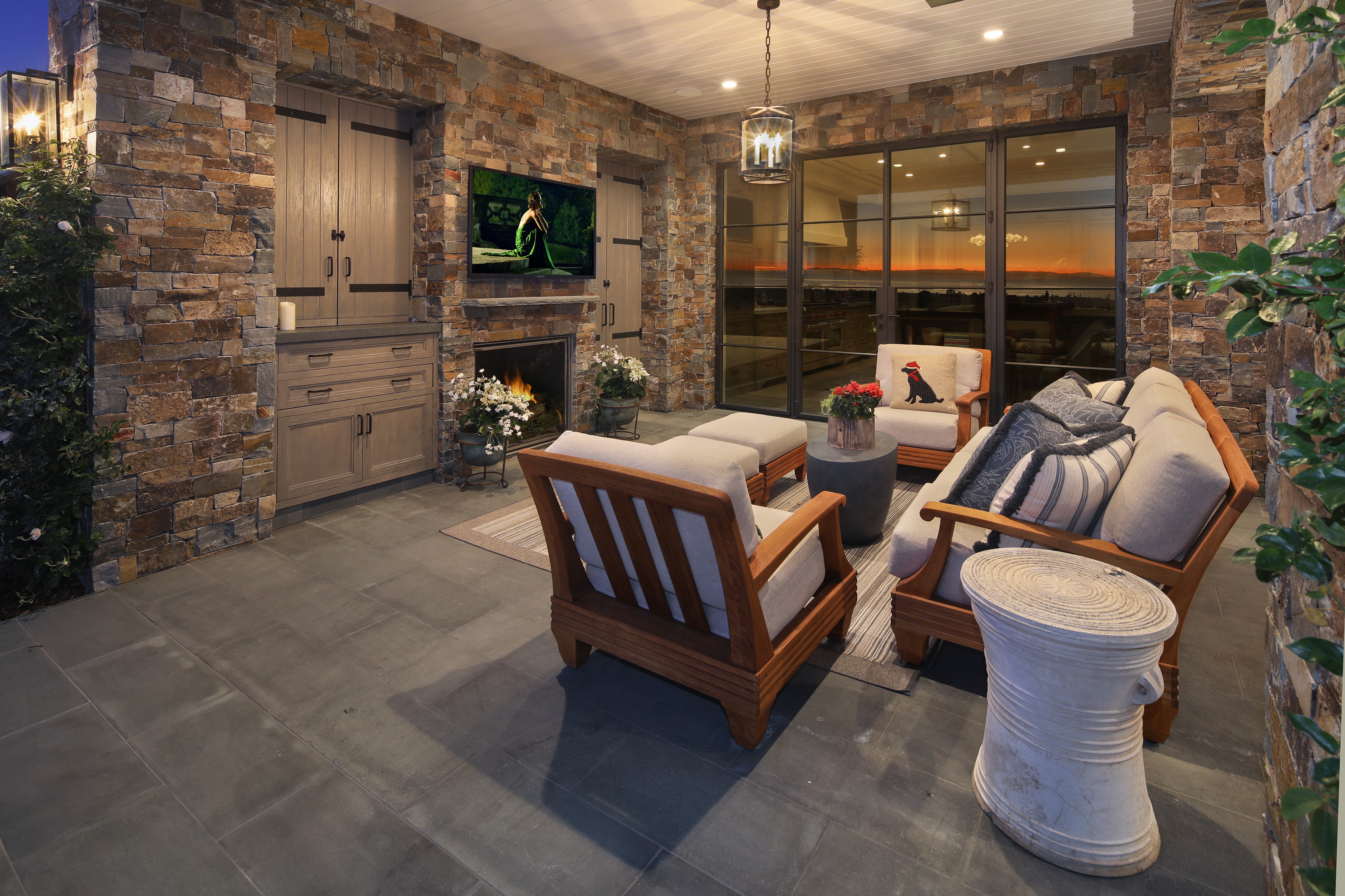 Outdoor living room with stone wall and fireplace HD Wallpaper