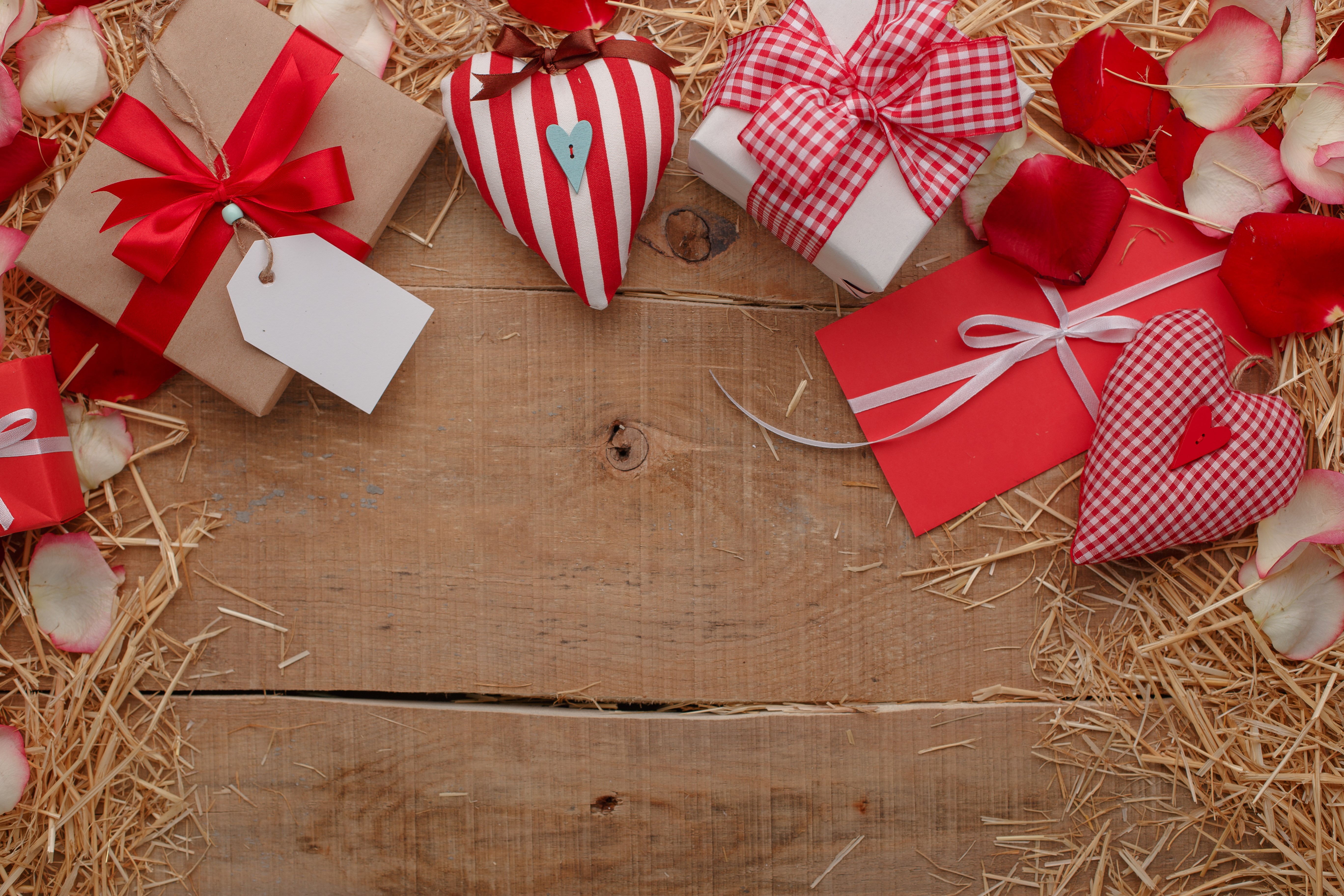 Valentine's Day gifts and hearts on wood planks with straw and petals HD Wallpaper