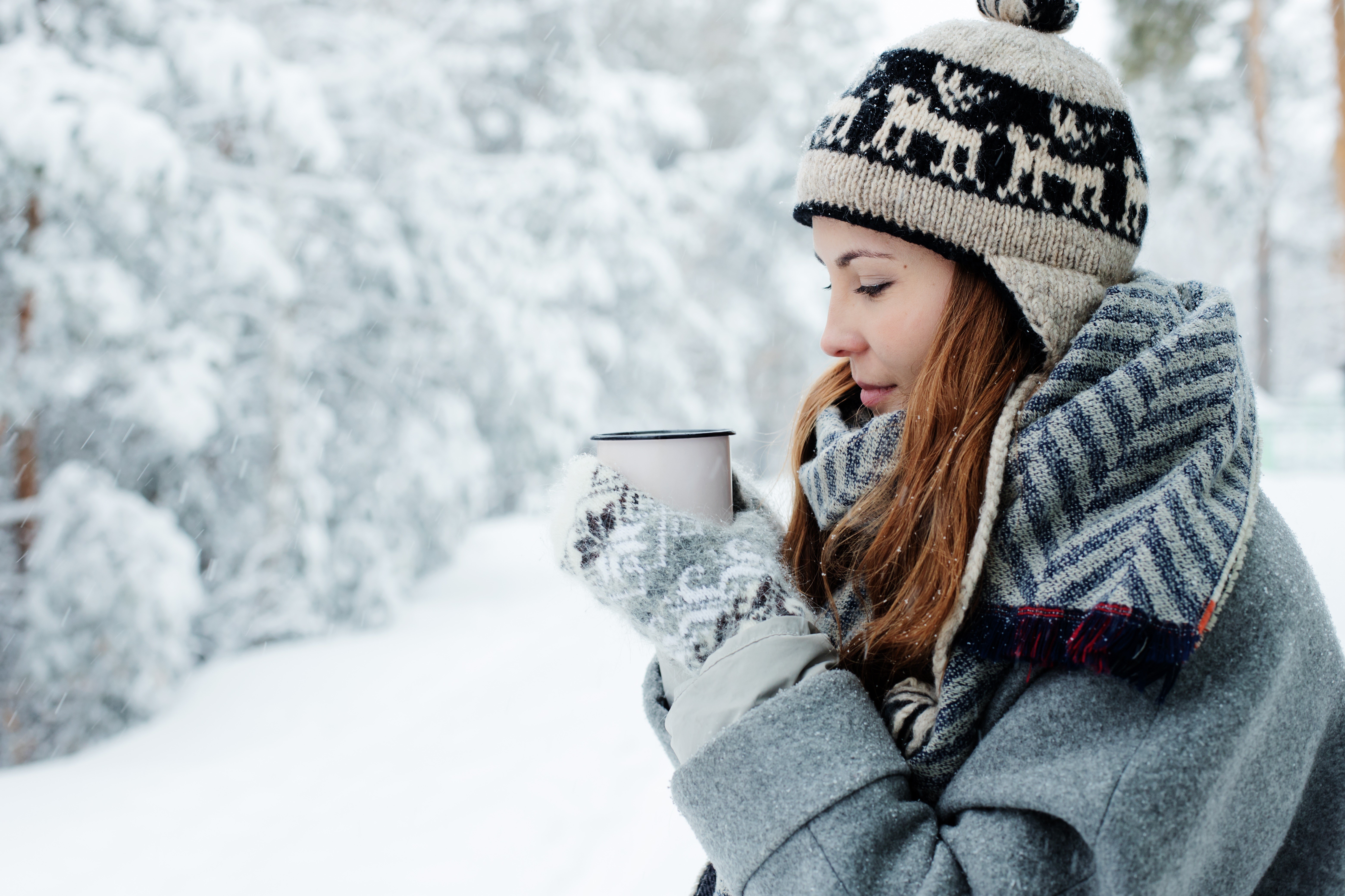 Woman in winter hat holding a mug in the snow HD Wallpaper
