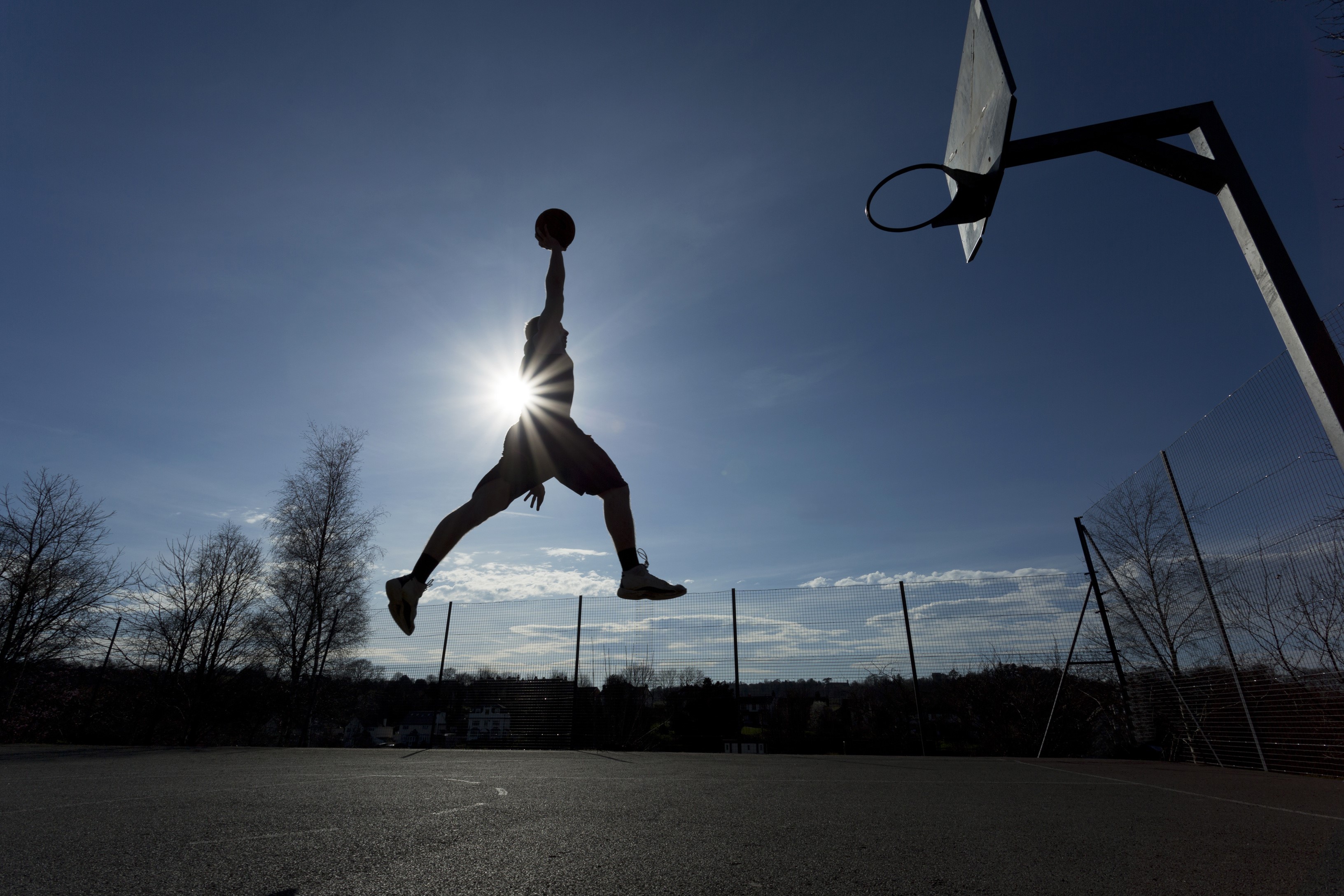 Silhouette of a man dunking a basketball HD Wallpaper