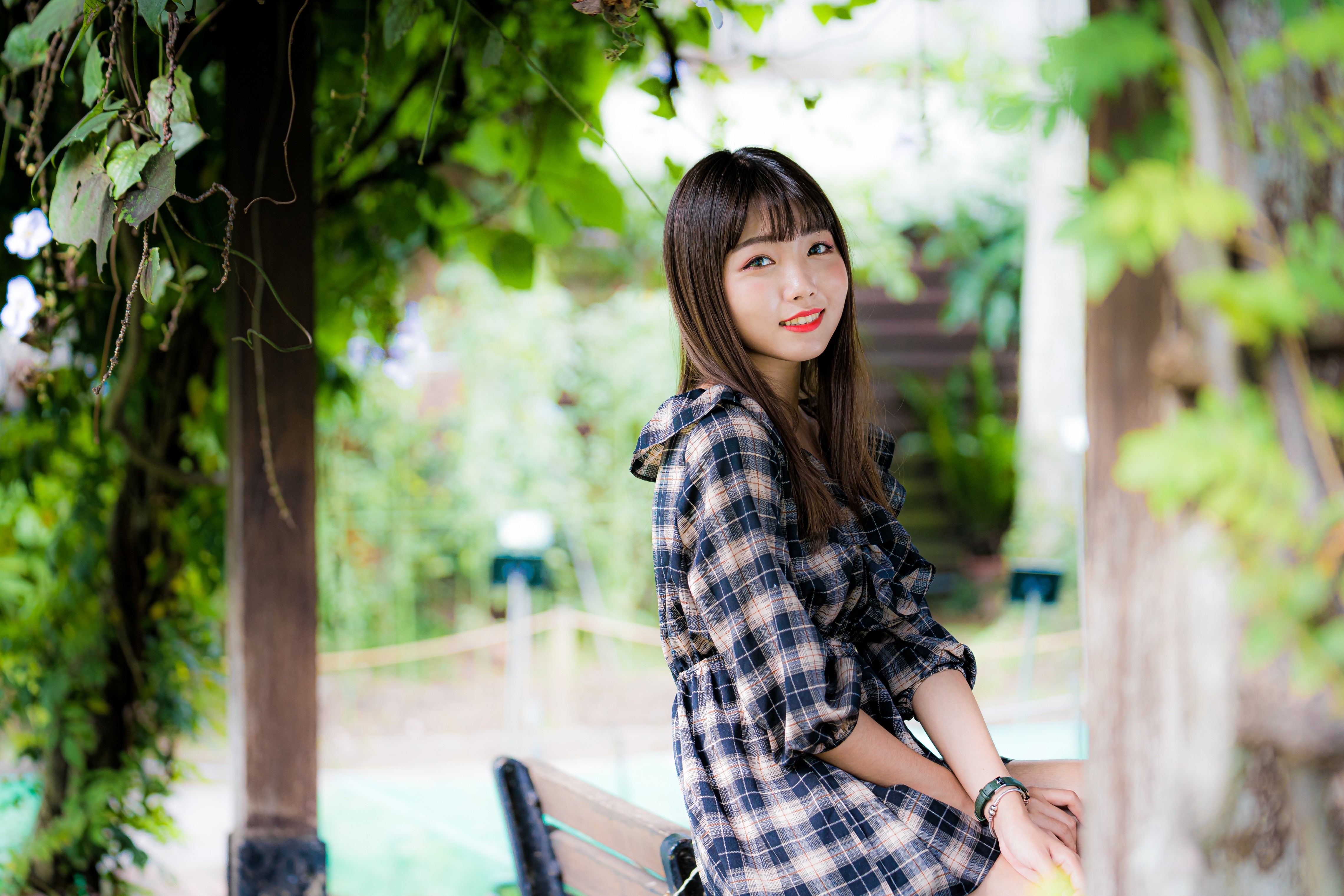 Brunette girl in plaid dress smiling HD Wallpaper