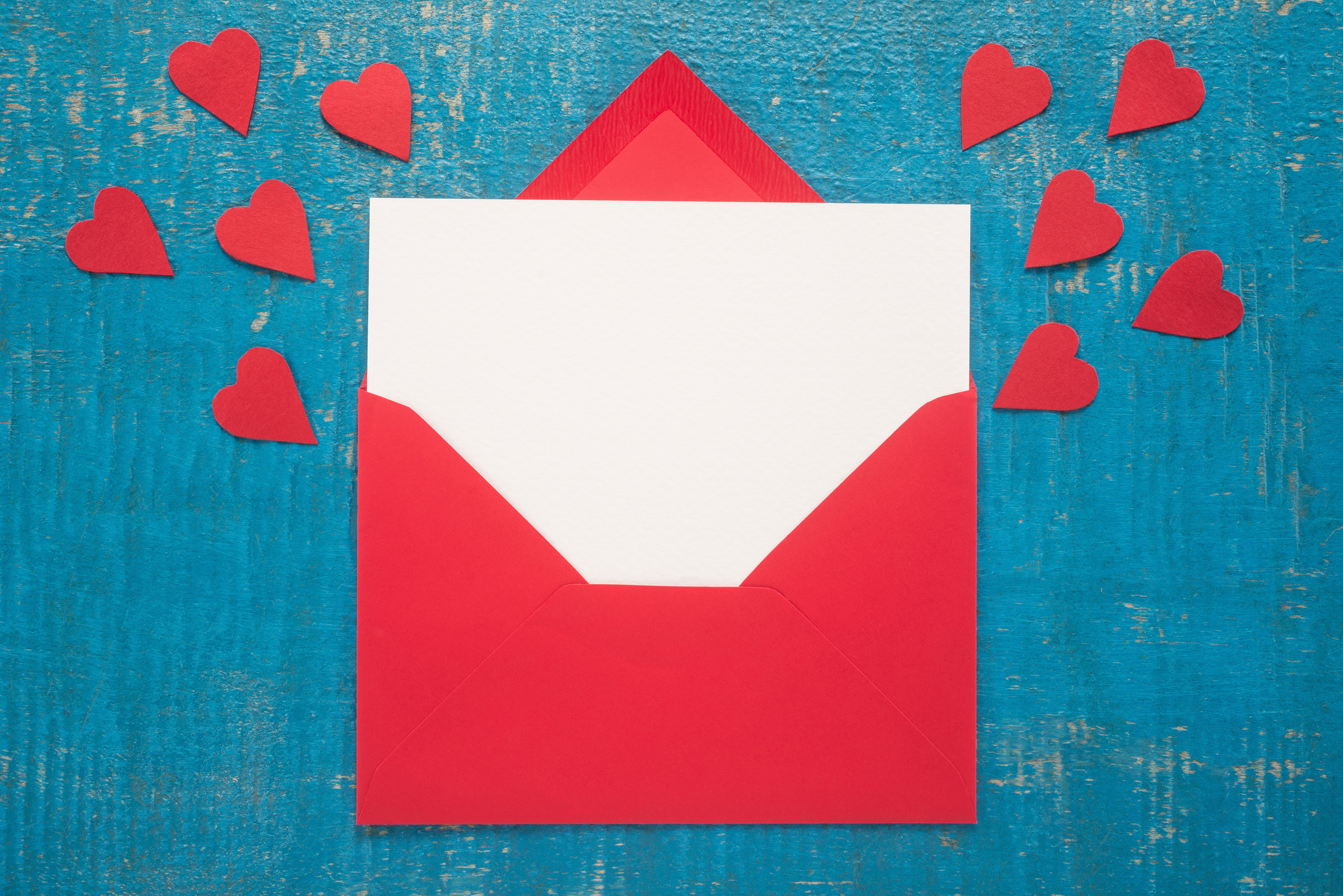 Red envelope with white paper and red hearts on blue wood HD Wallpaper