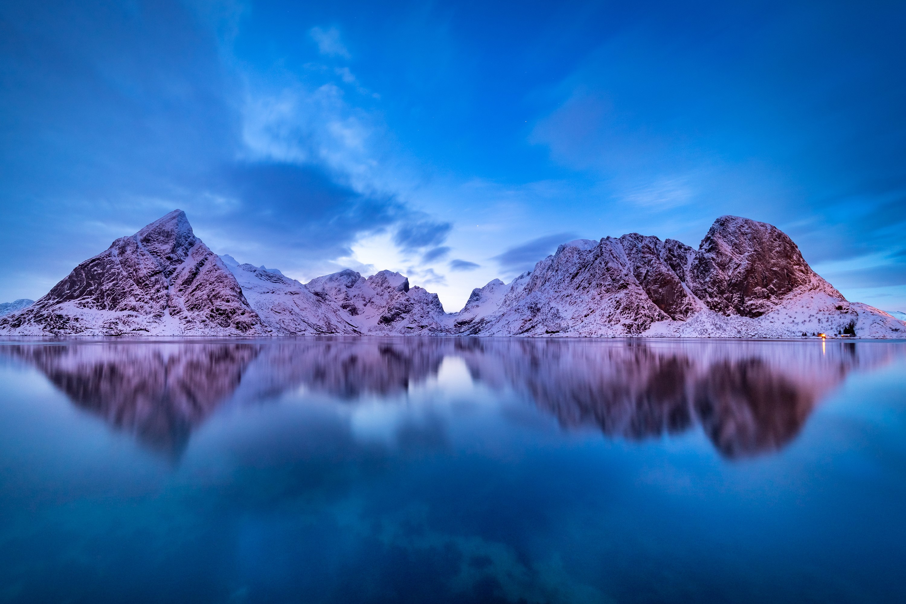 Snow-covered mountains reflected in calm water at dusk HD Wallpaper