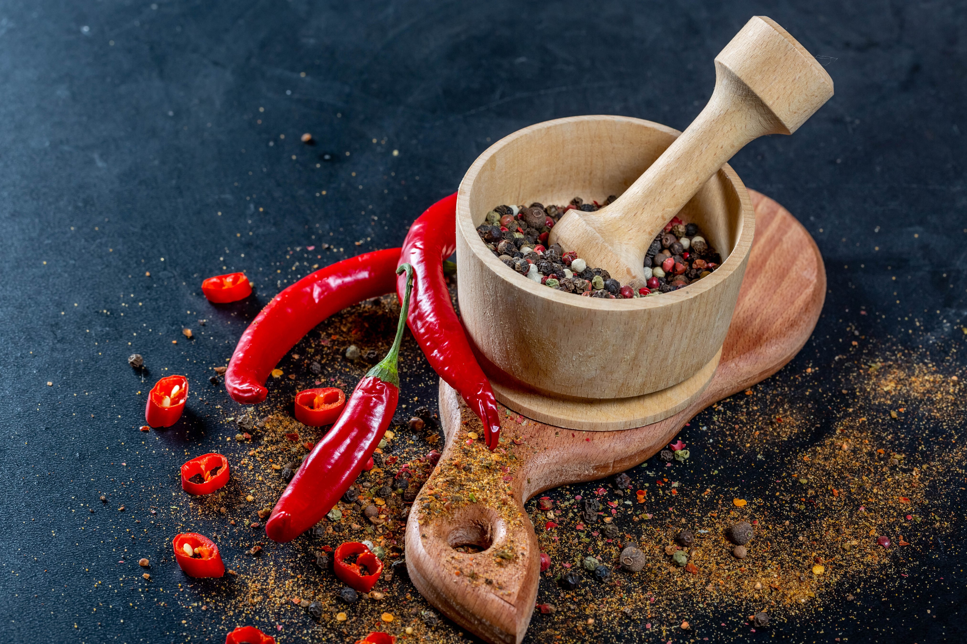 Chili peppers and spices in mortar and pestle HD Wallpaper