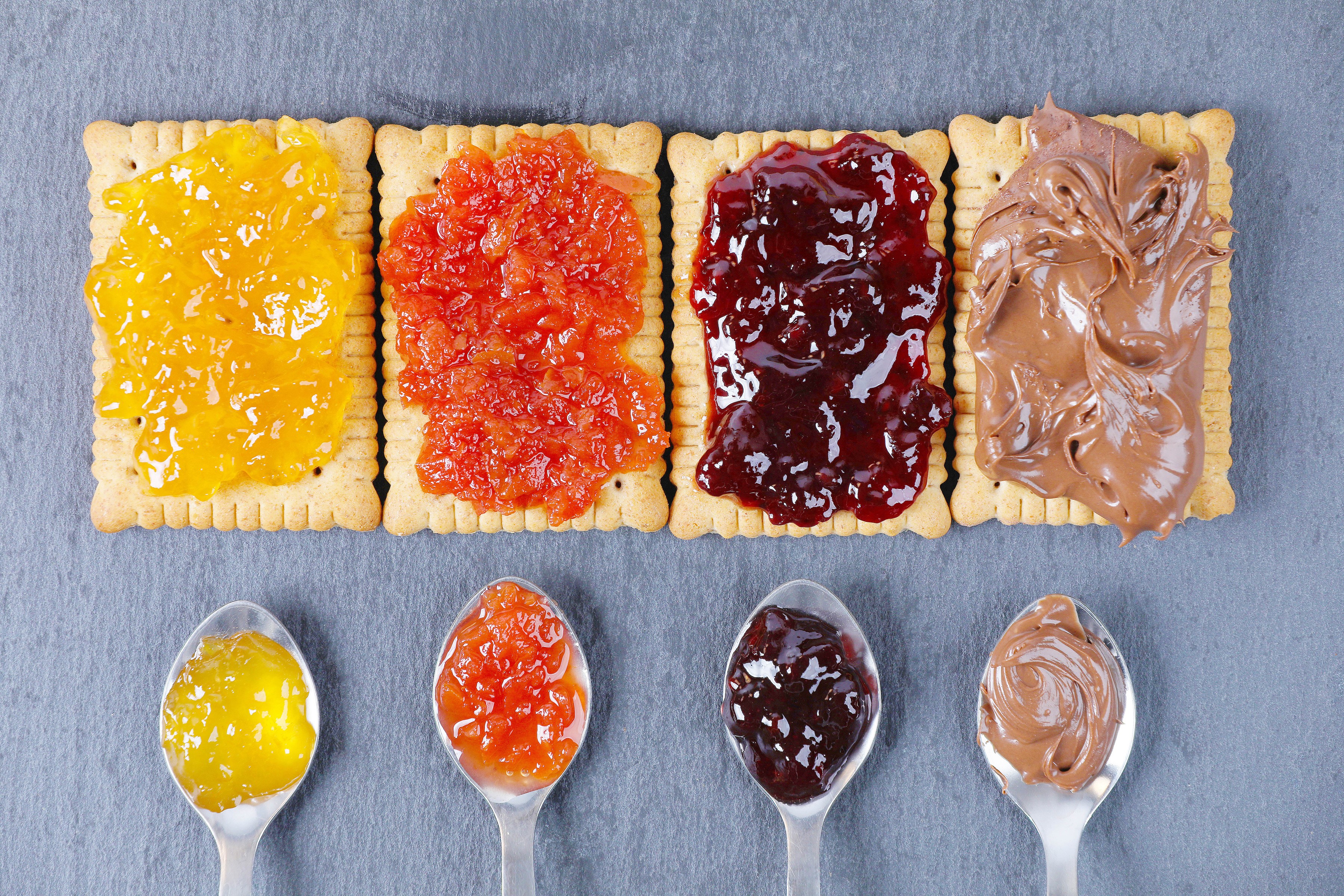 Cookies with jam and chocolate spread on spoons HD Wallpaper