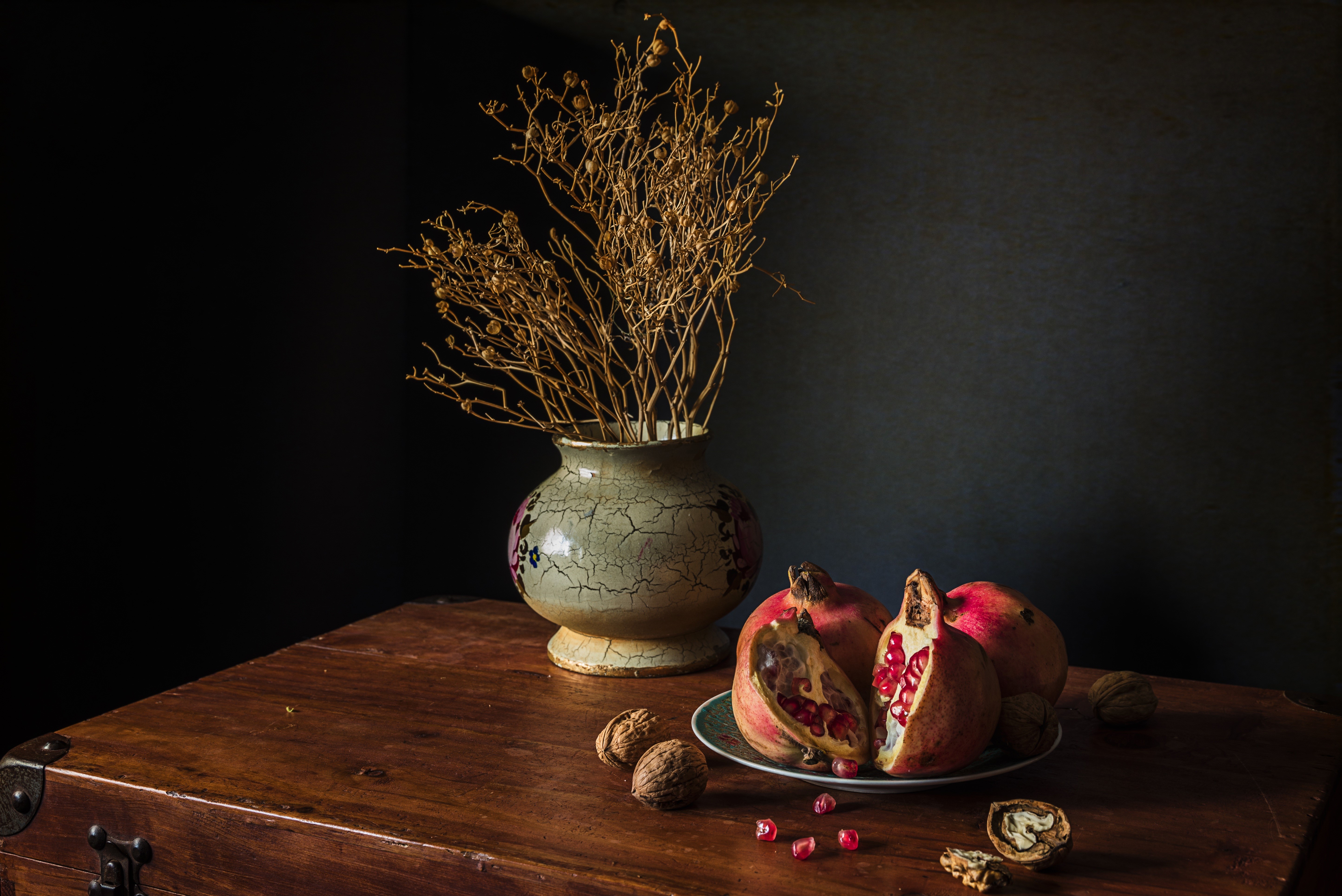 Still-life with pomegranates, walnuts, and a vase of dried flowers HD Wallpaper