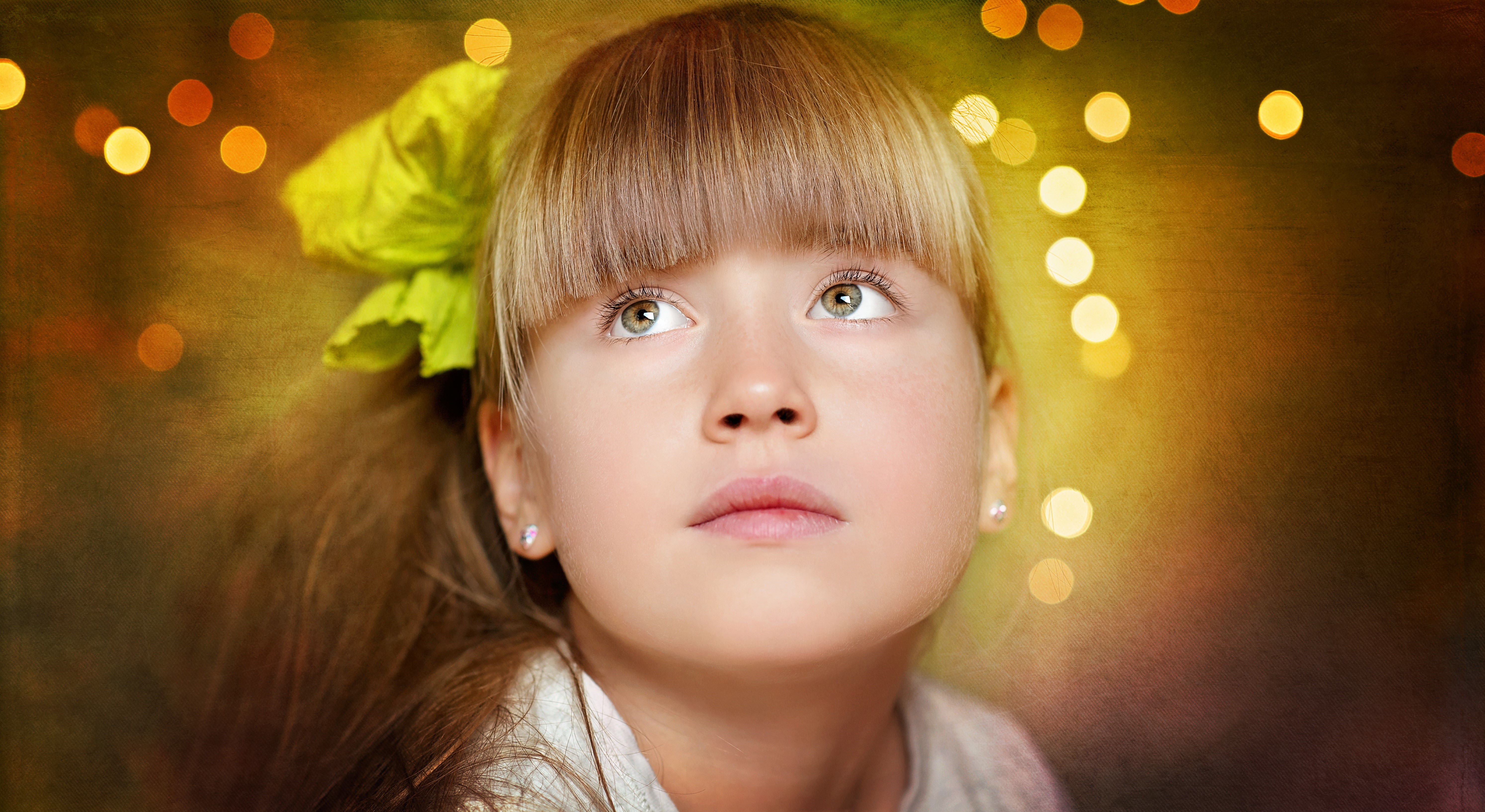 Cute girl with dark blonde hair and a yellow bow looking up HD Wallpaper