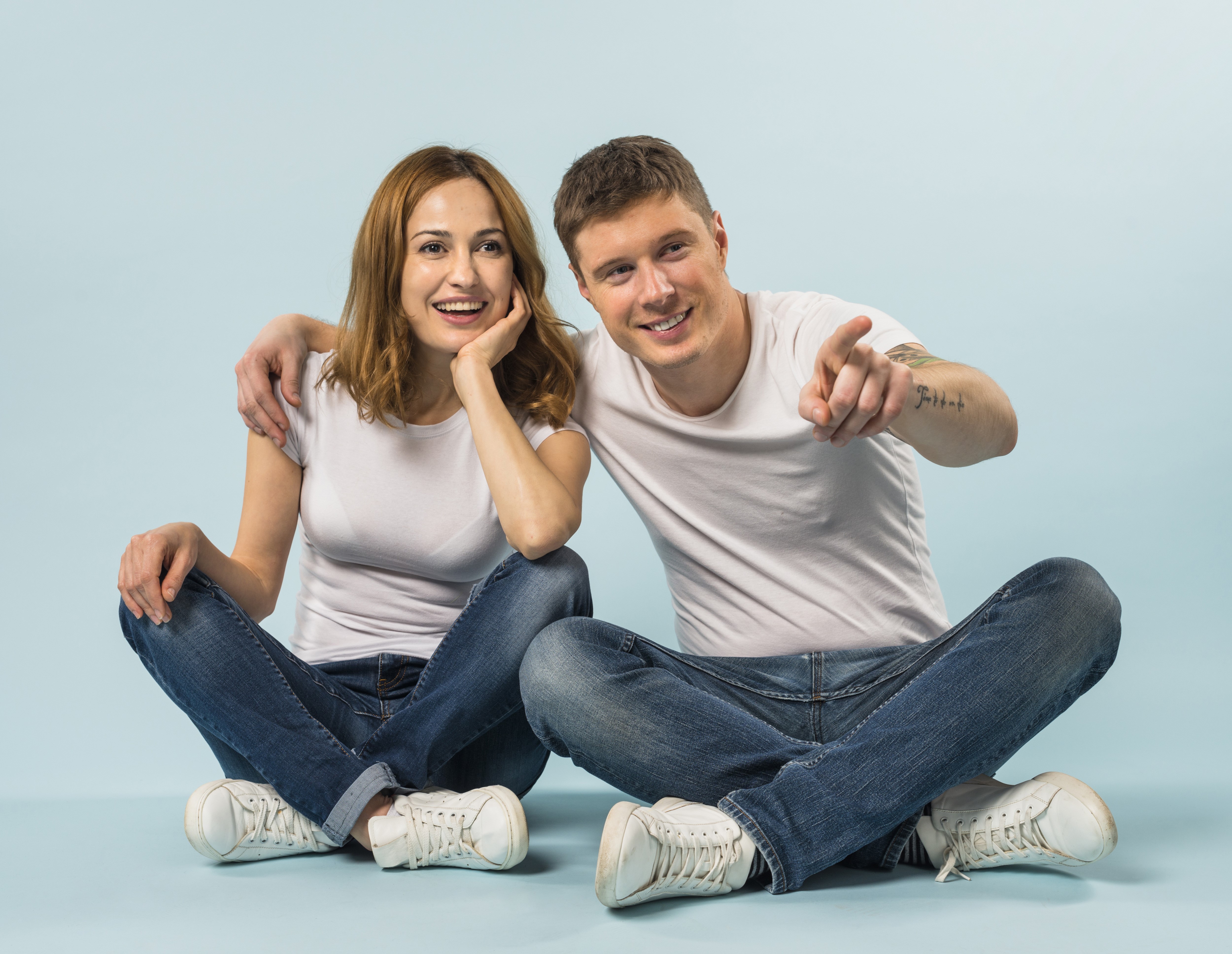 Couple sitting on floor, man pointing HD Wallpaper