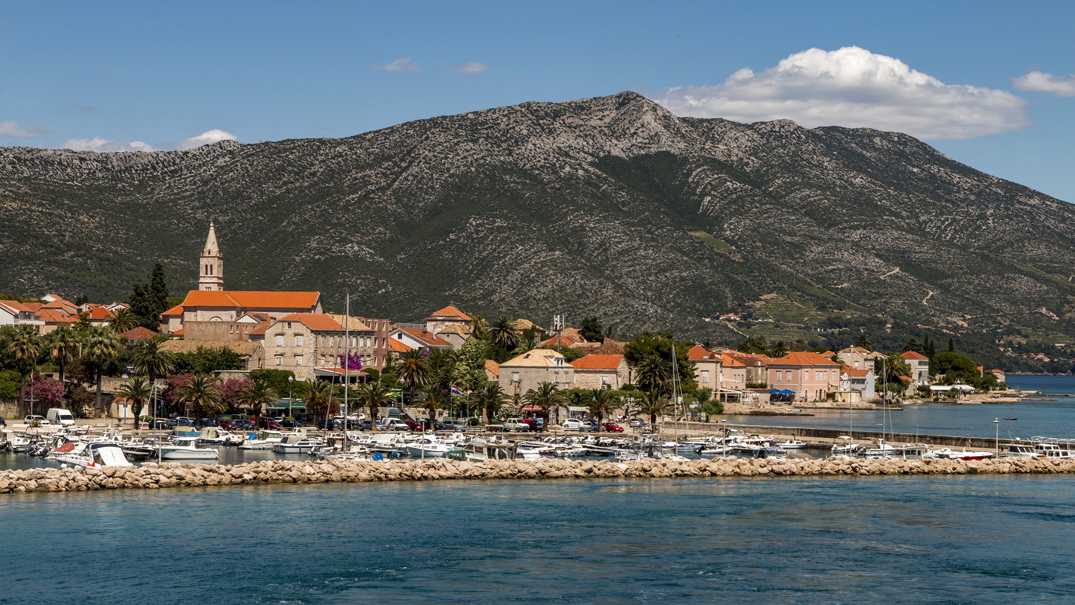 Coastal town with marina and mountain backdrop in Croatia HD Wallpaper