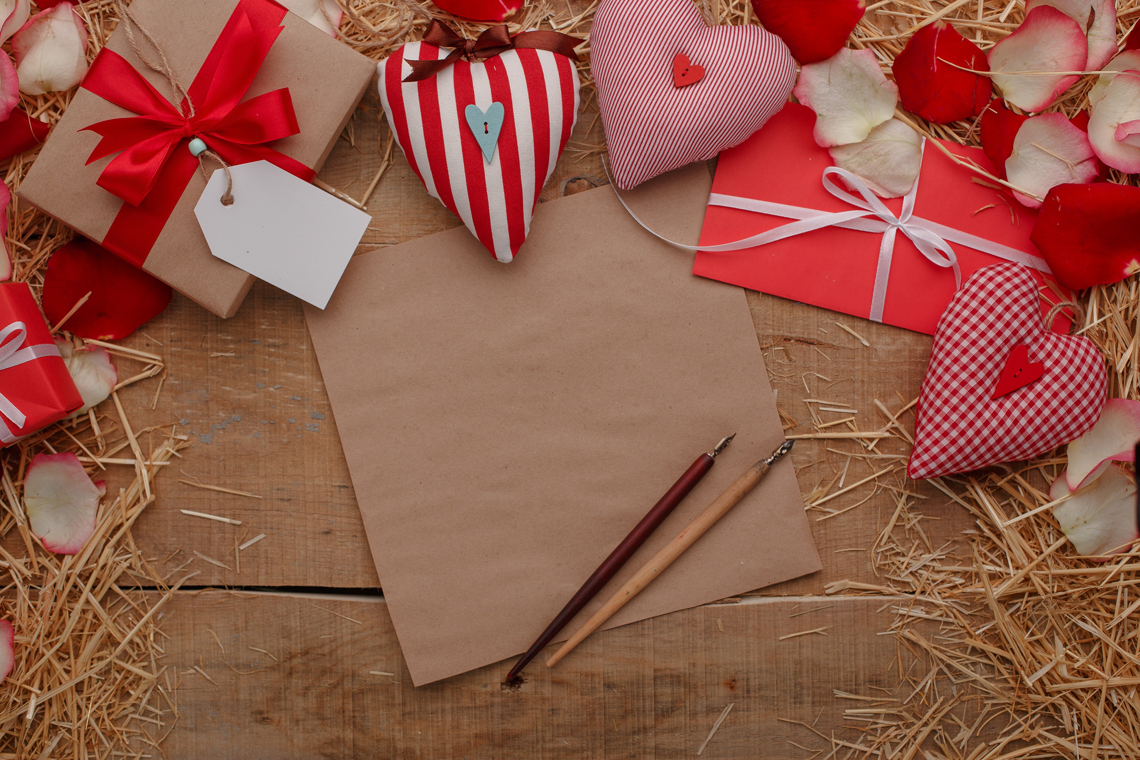 Valentine's Day gift box, hearts, and writing tools on wood HD Wallpaper