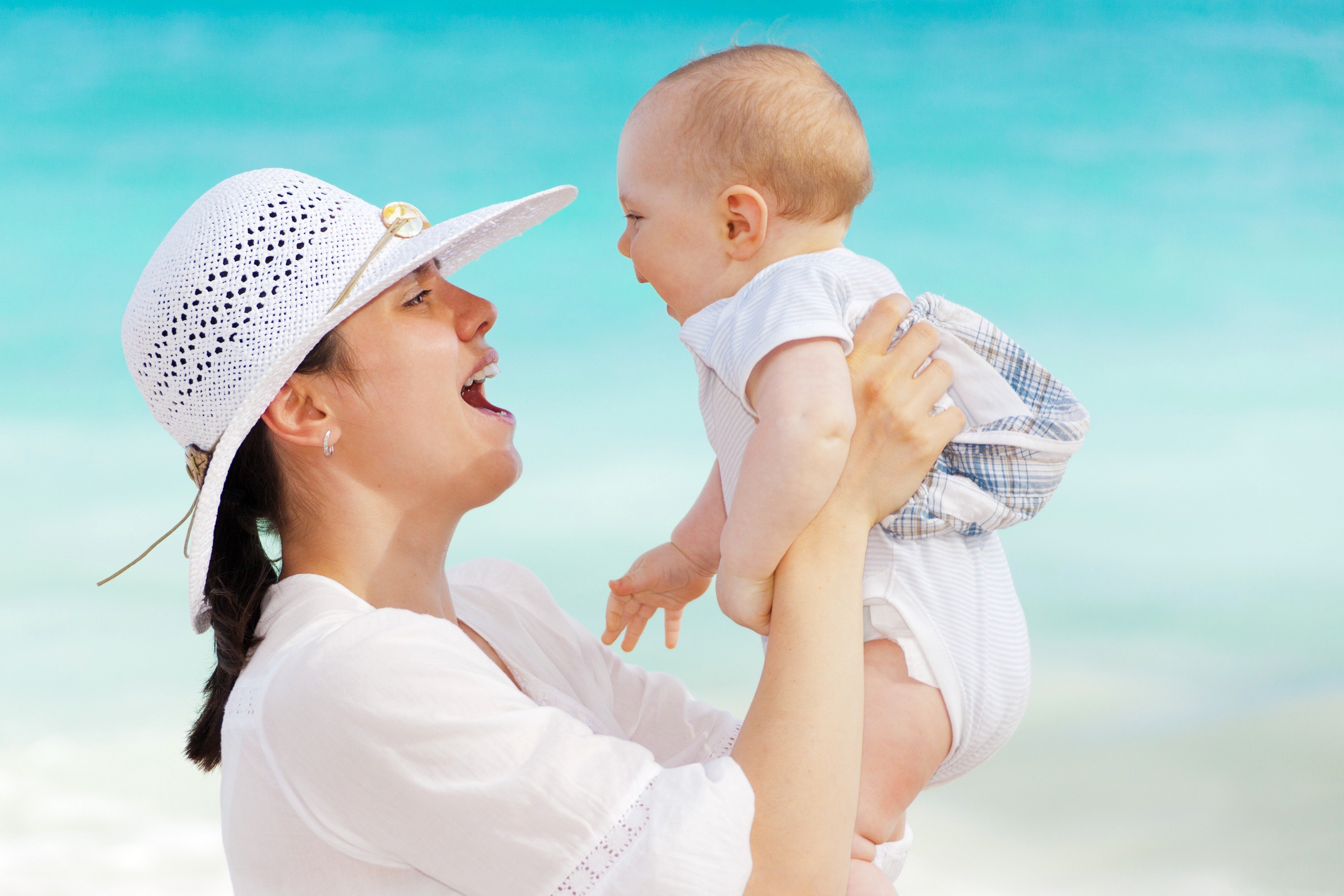 Mother holding baby on beach HD Wallpaper