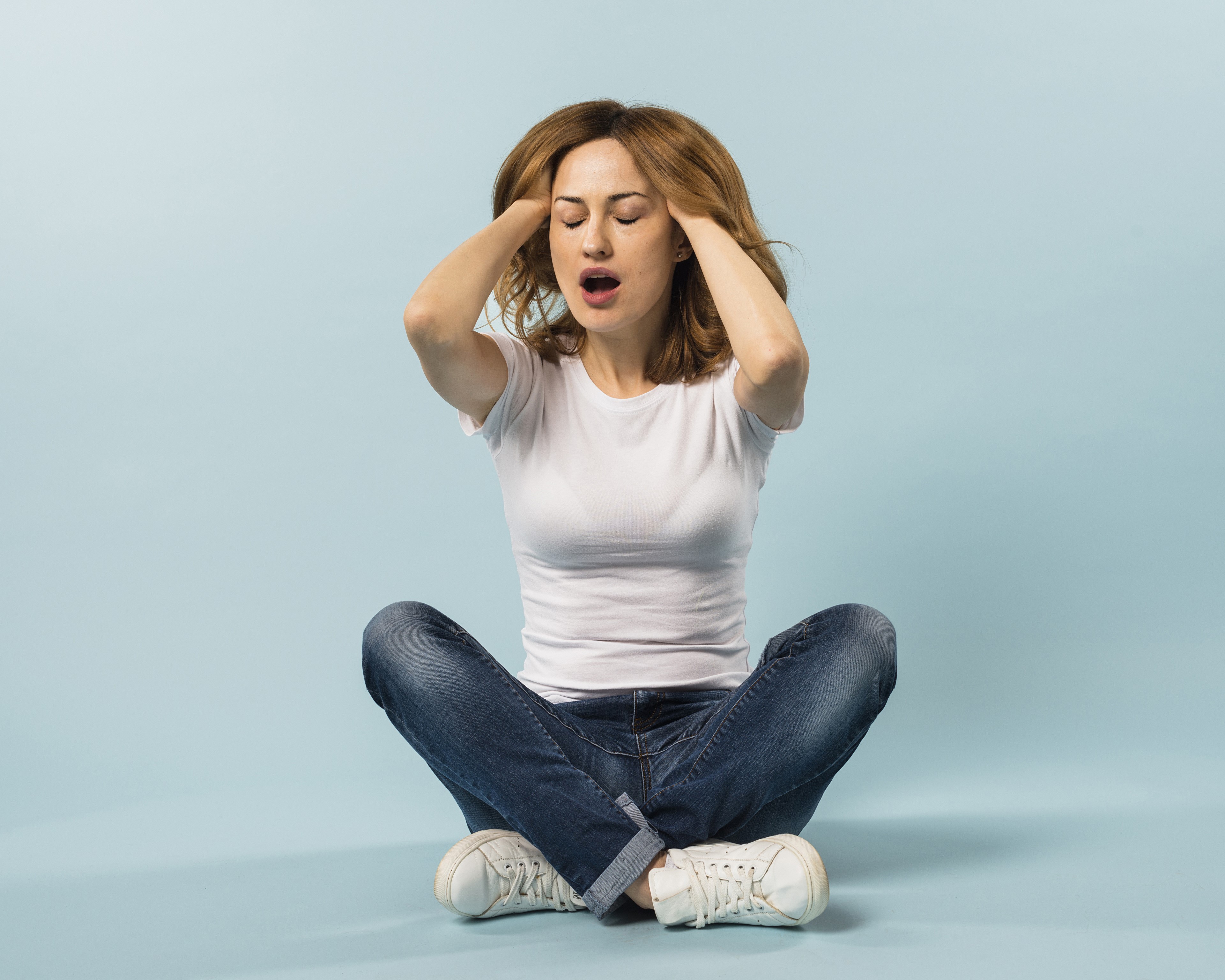 Woman sitting with hands on head HD Wallpaper