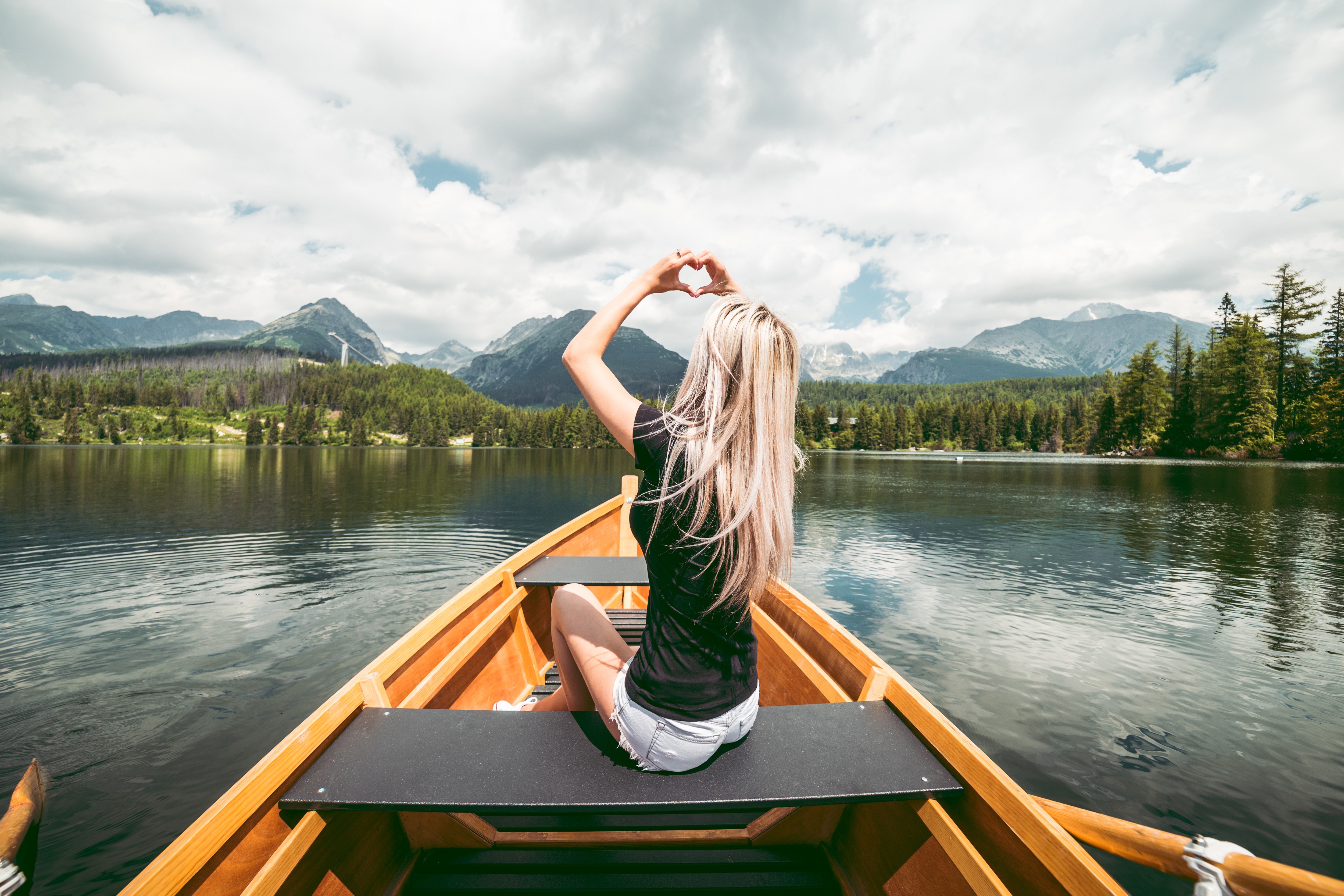 Woman in a boat making a heart shape with hands HD Wallpaper
