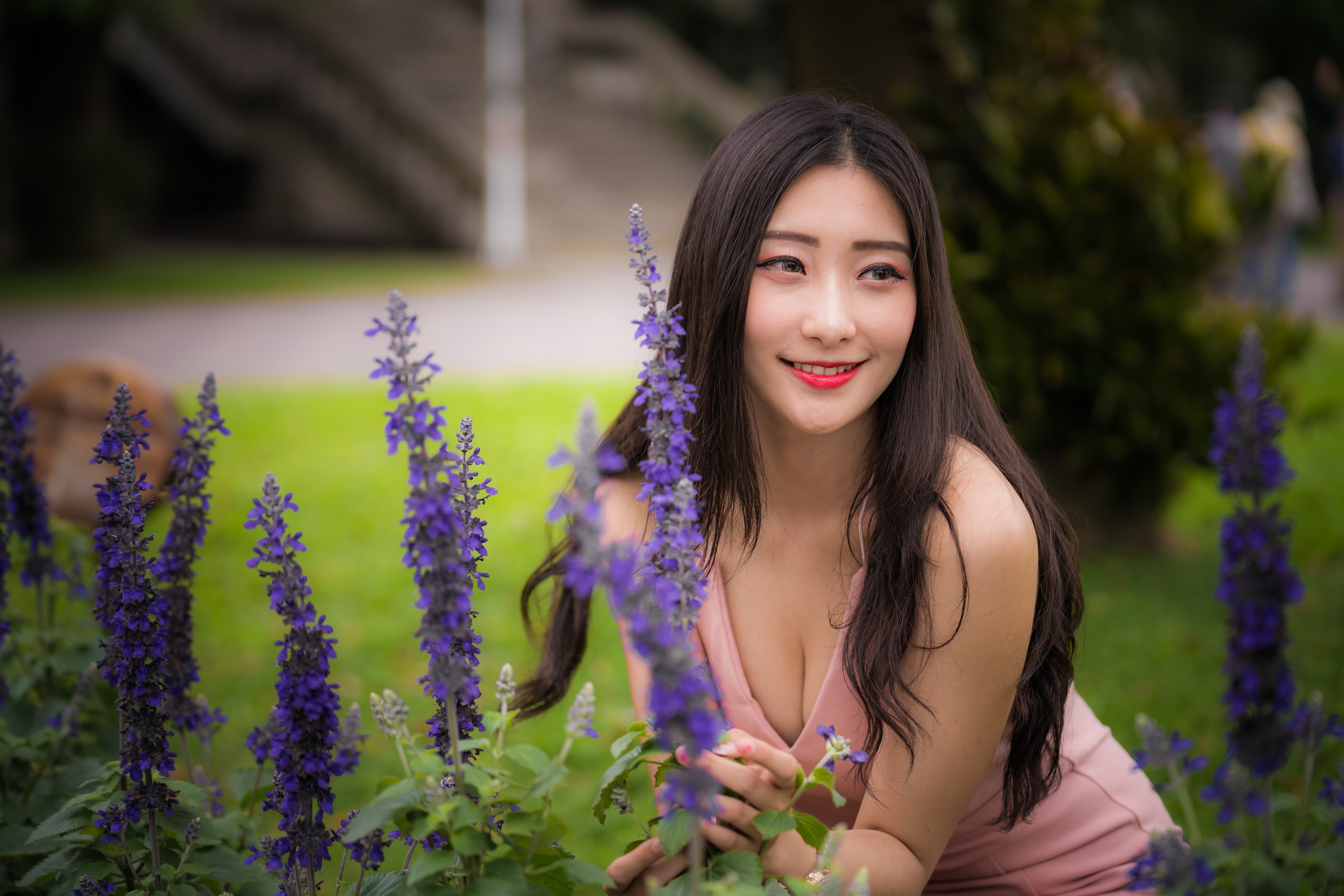 Asian woman smiling among purple flowers HD Wallpaper