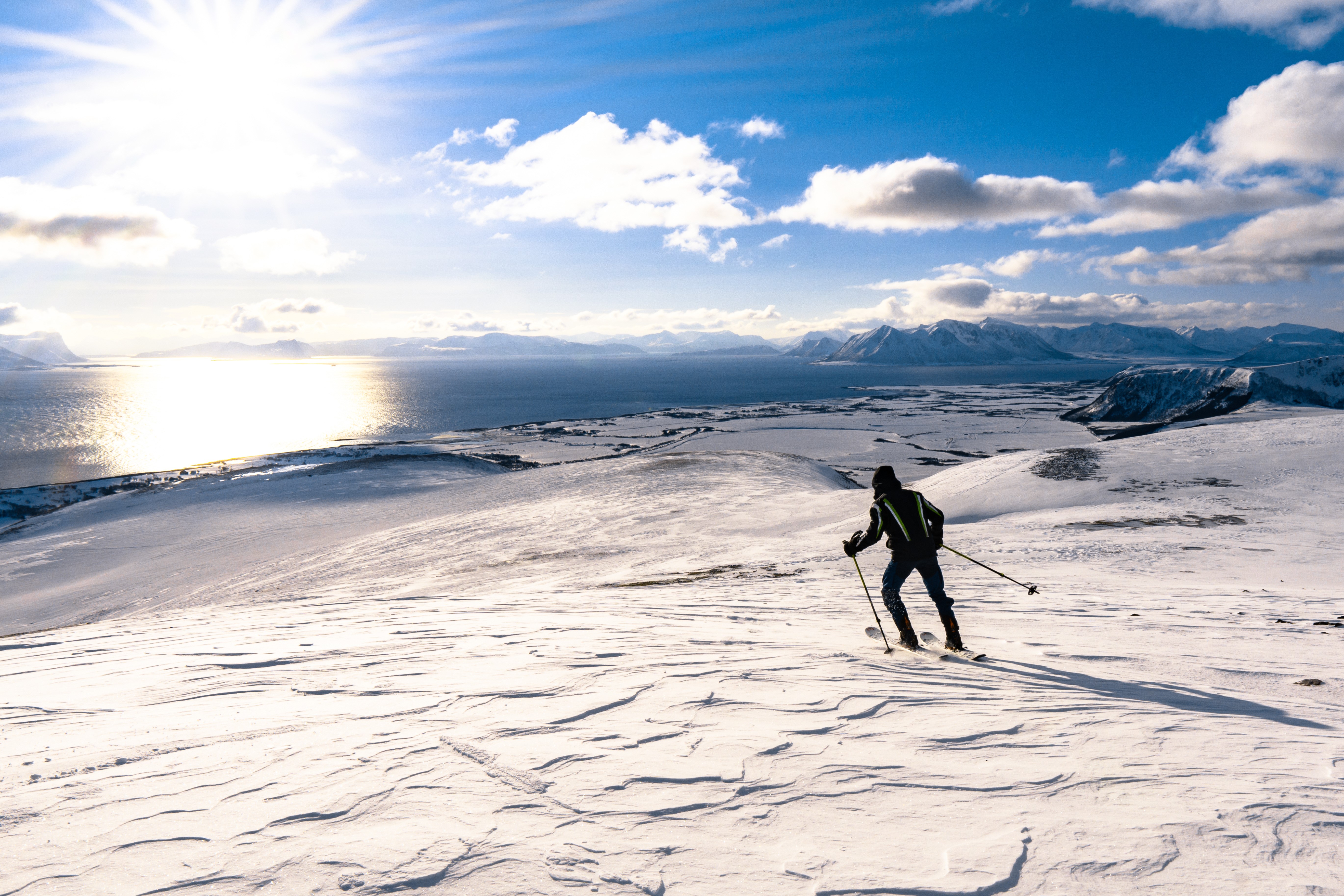 Skiing on a snowy mountain overlooking the ocean HD Wallpaper