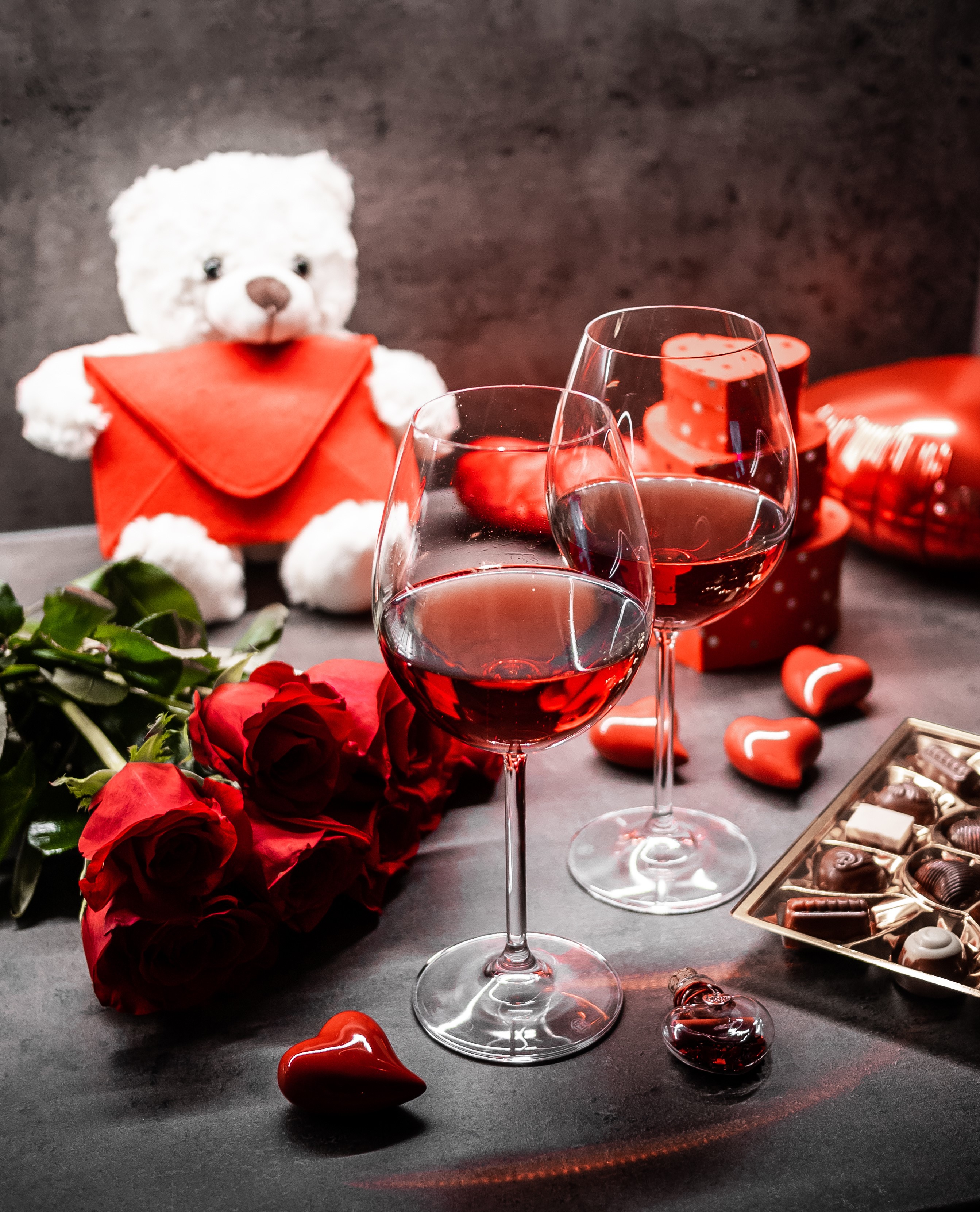 Valentine's Day setting with wine, roses, and chocolates HD Phone Wallpaper