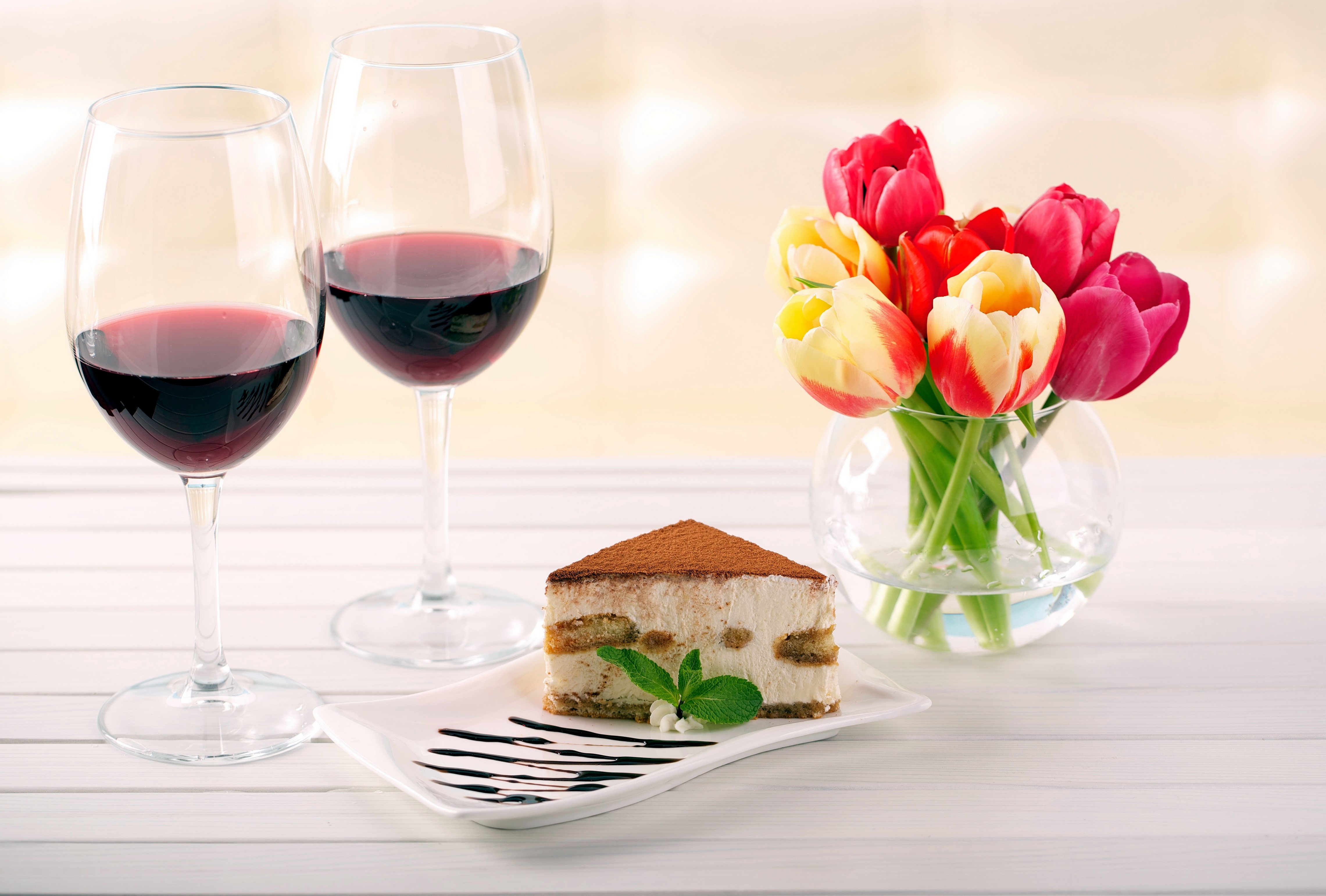 Two glasses of red wine, tiramisu, and tulips HD Wallpaper