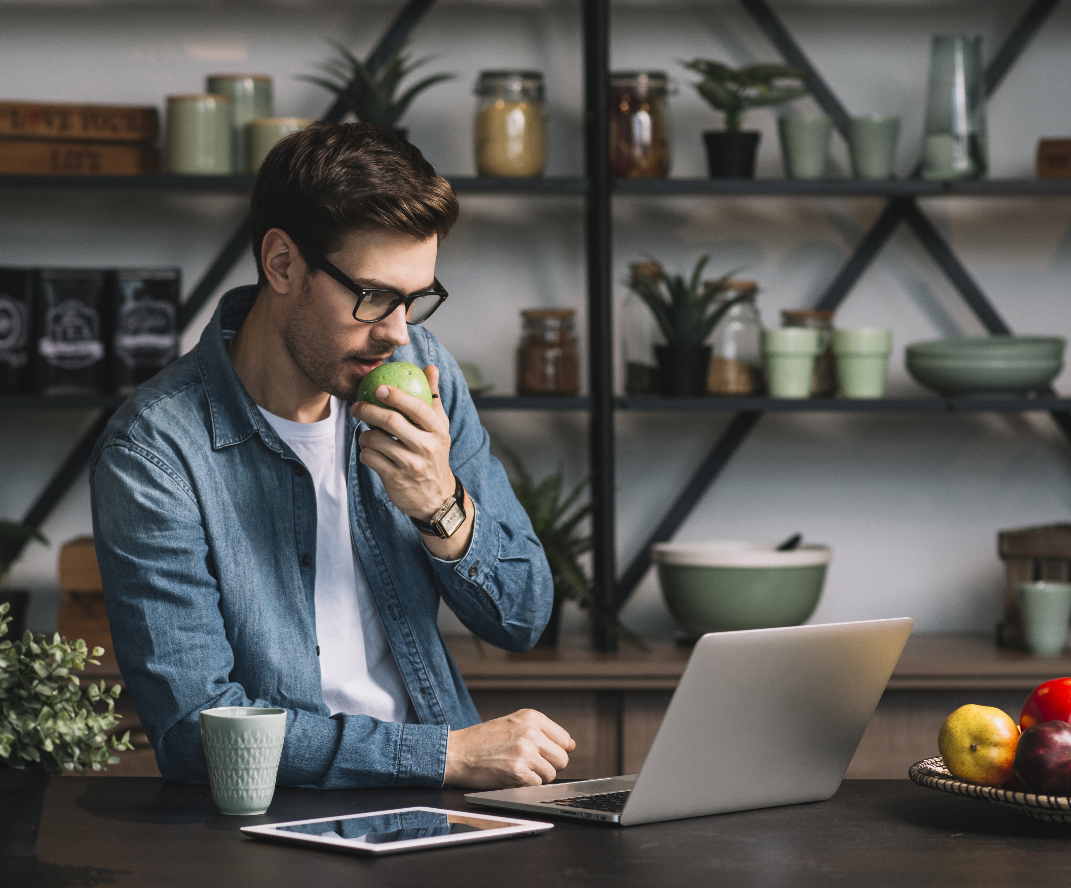 Man in Glasses Eating Apple at Laptop HD Wallpaper