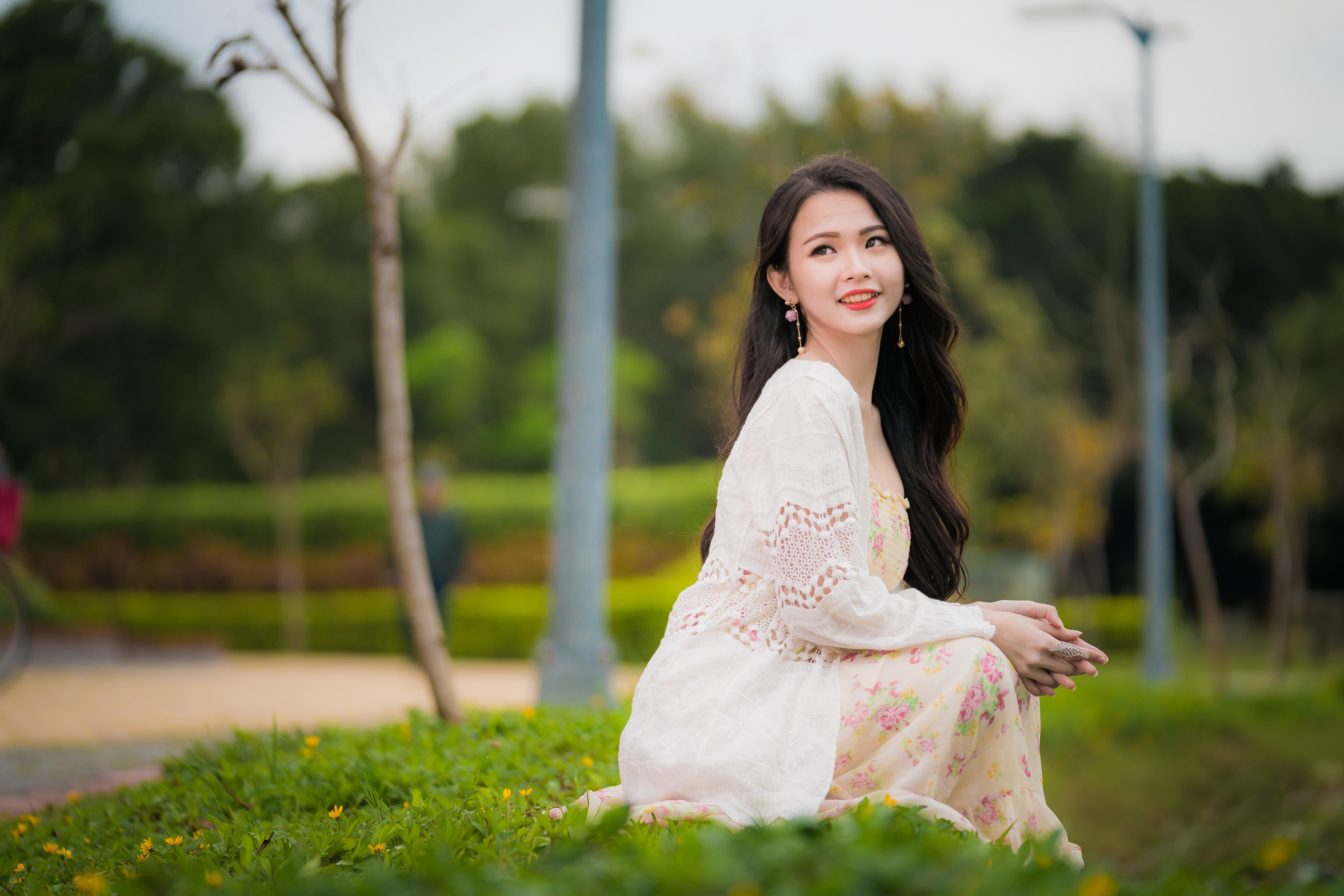 Asian woman in dress sitting in park HD Wallpaper