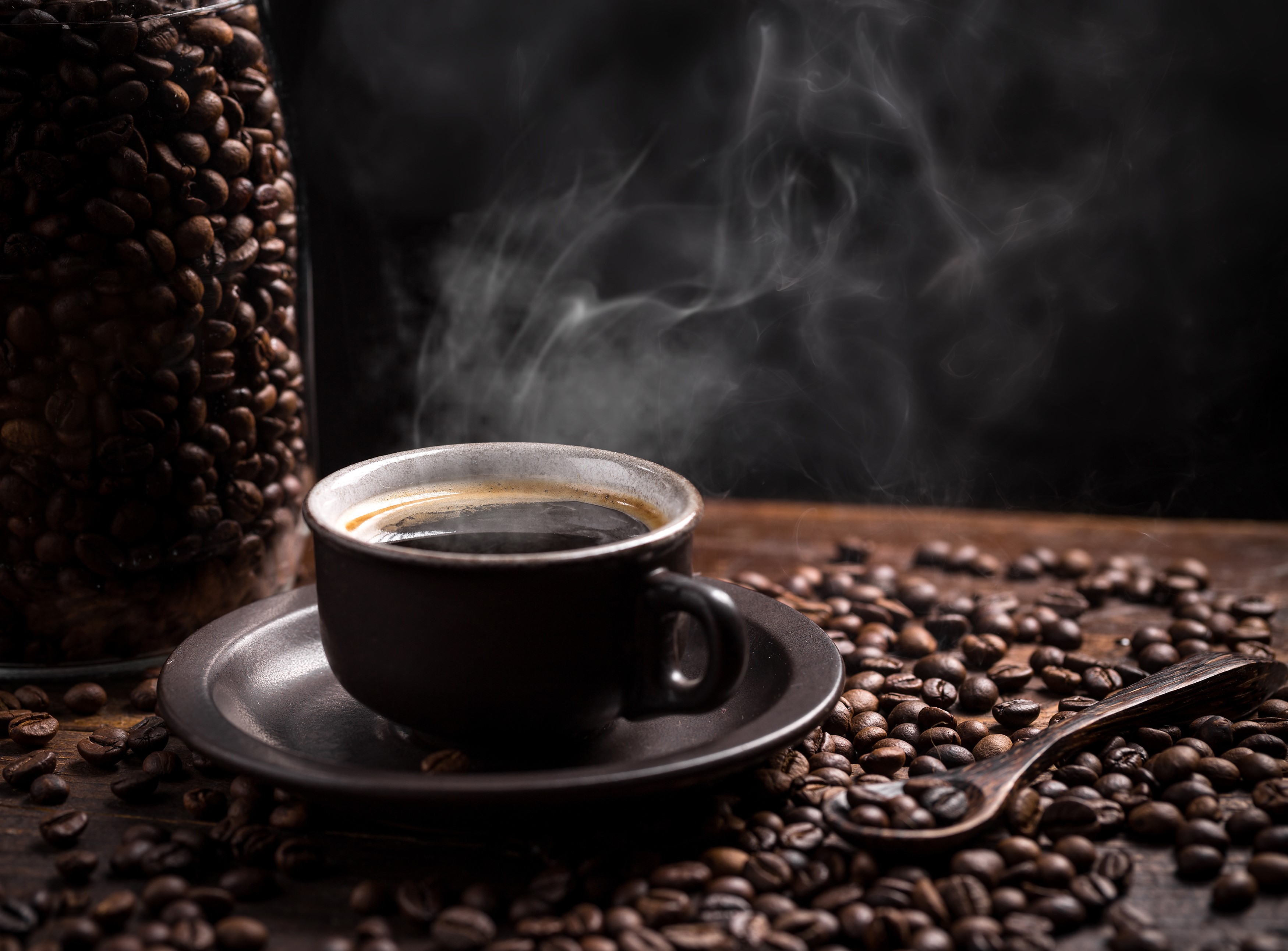 Steaming cup of coffee with coffee beans HD Wallpaper