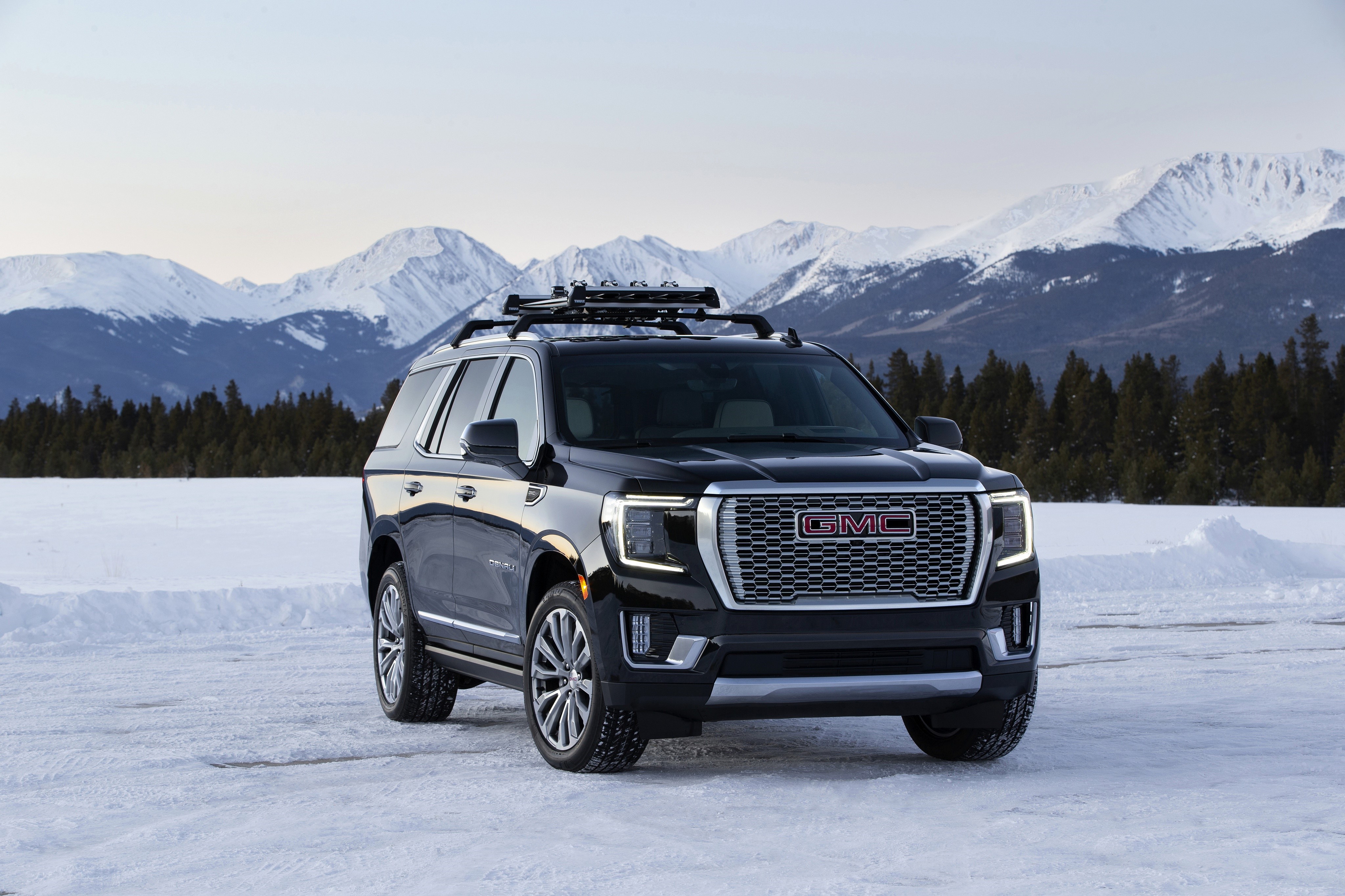 GMC Yukon Denali SUV in snowy mountains HD Wallpaper