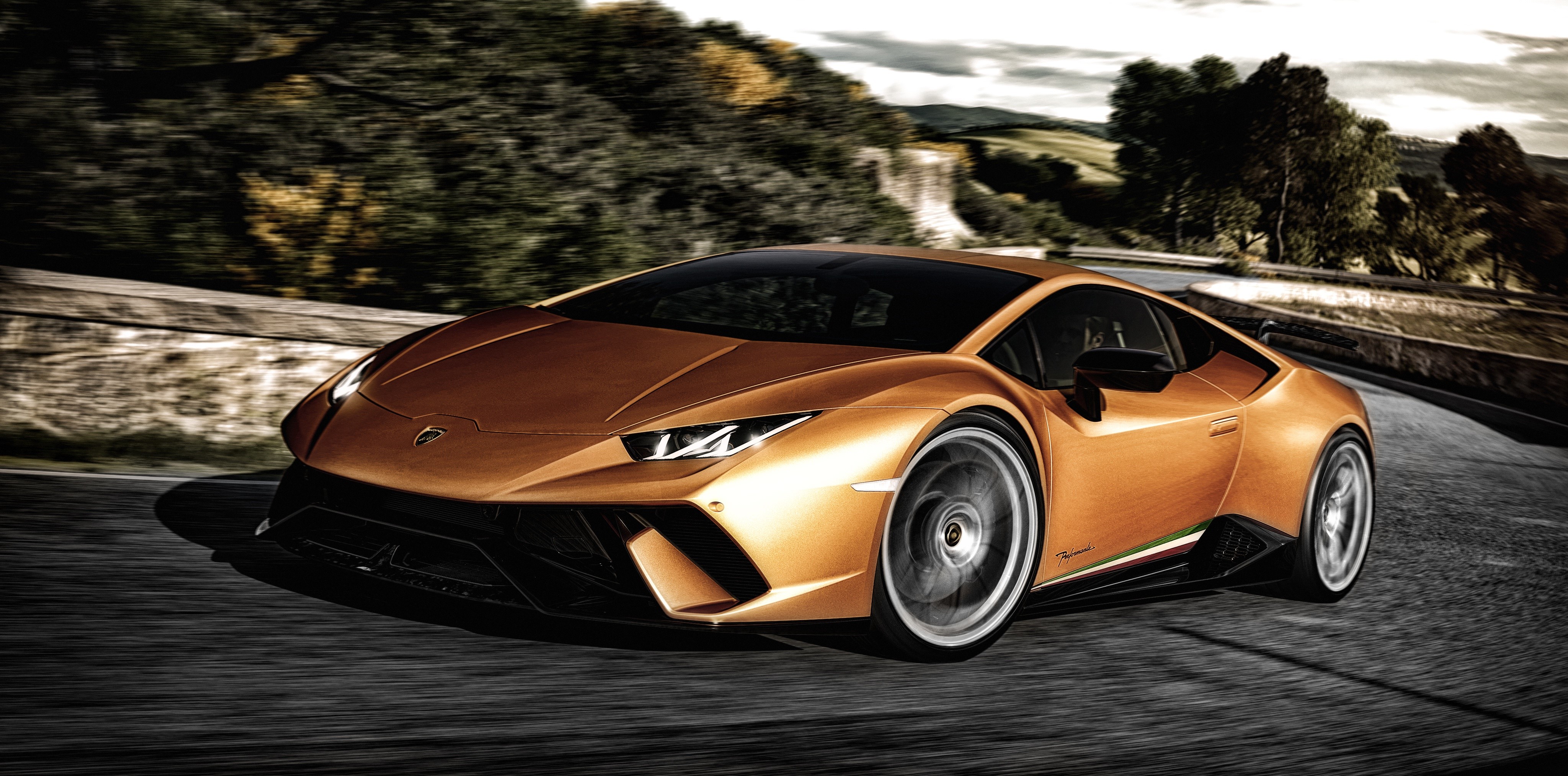 Lamborghini Huracan driving on a road HD Wallpaper