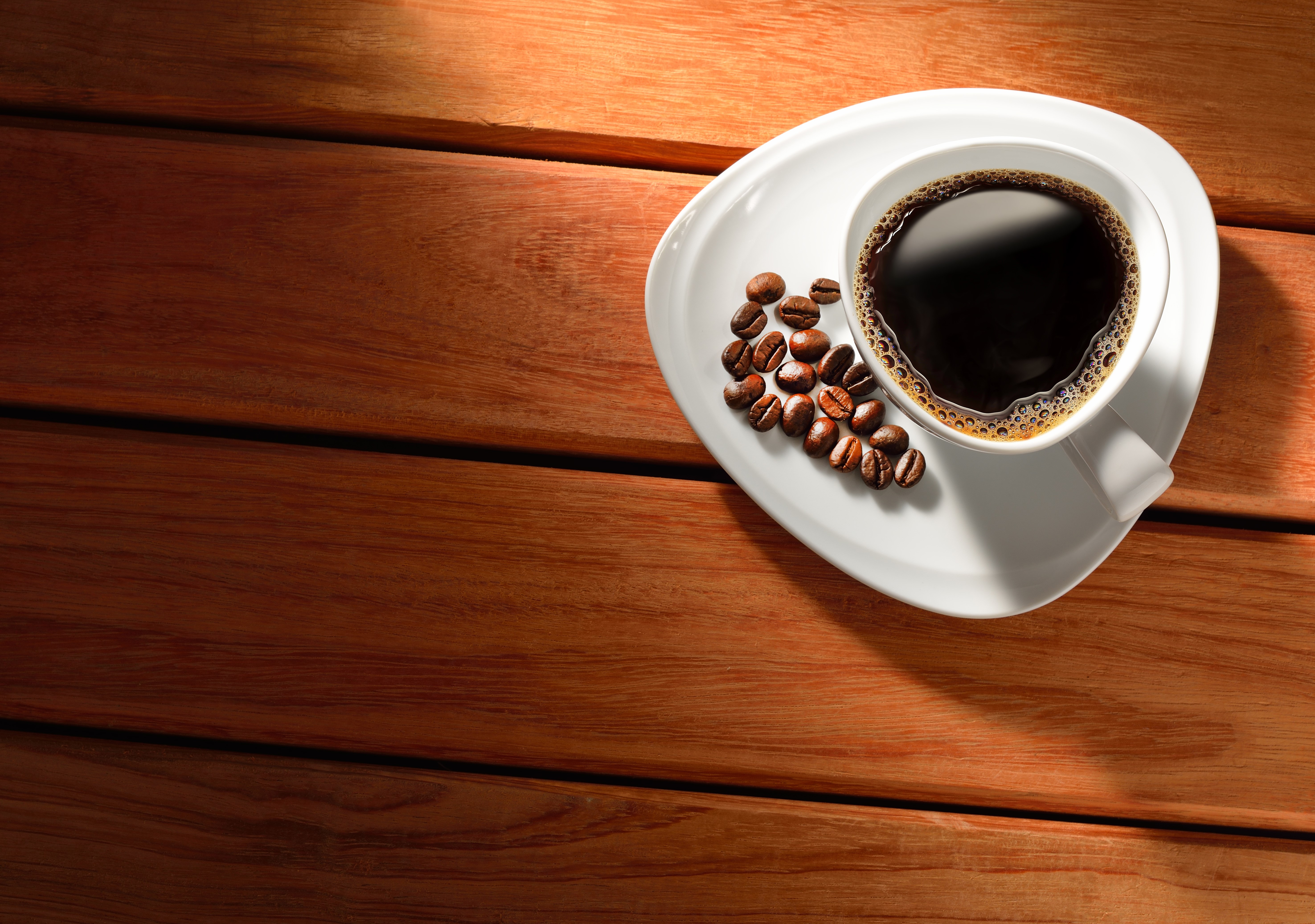 Coffee cup with beans on saucer on wood HD Wallpaper